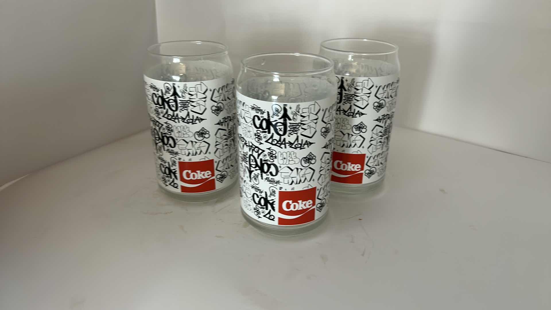 Photo 1 of COCA-COLA 7 PIECE GLASSWARE SET WITH BLACK & WHITE GRAPHIC DESIGN- COLLECTIBLE COKE DRINKING GLASES ESTIMATED RETAIL VALUE:$50