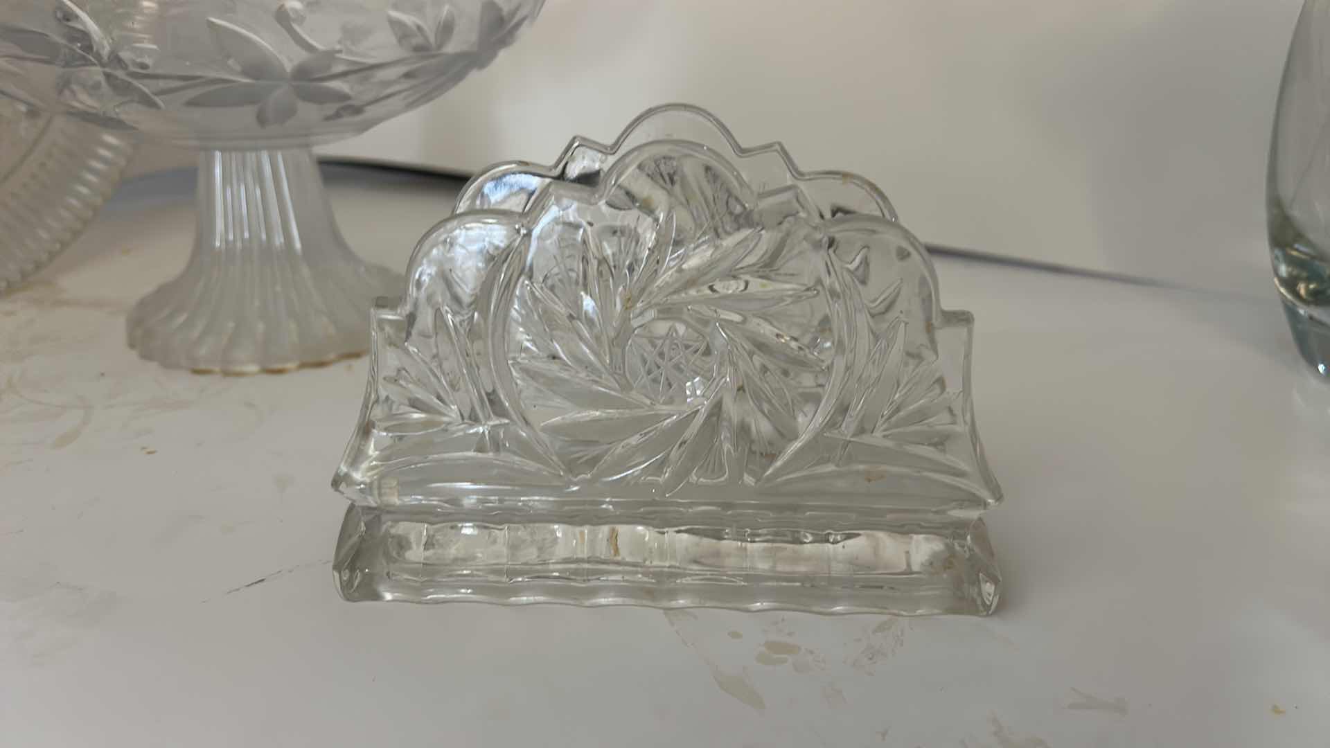 Photo 1 of ASSORTED VINTAGE CLEAR PRESSED GLASS SERVING PIECES INCLUDING DECORATIVE ROUND PLATTER, PEDESTAL COMPOTE AND FLORAL RELIEF DISH.
ESTIMATED RETAIL VALUE: $40–$60 FOR THE GROUP.