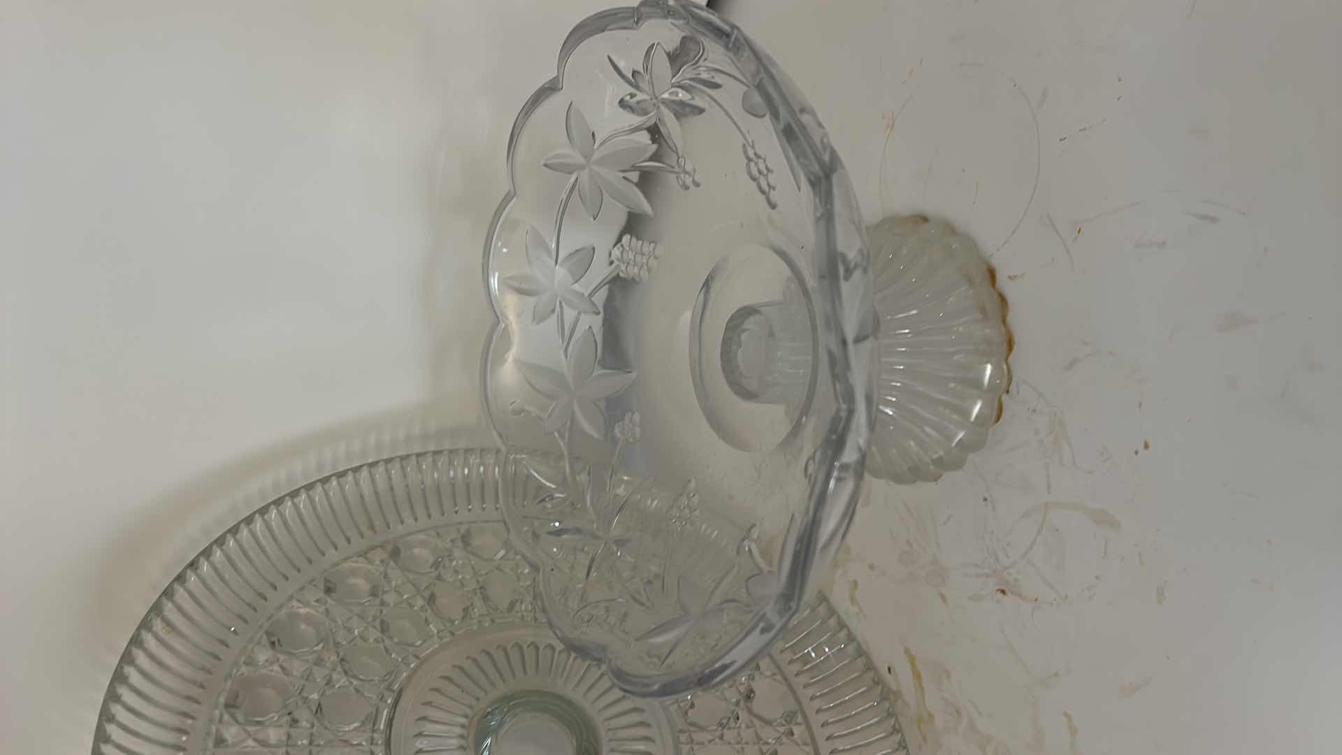Photo 1 of ASSORTED VINTAGE CLEAR PRESSED GLASS SERVING PIECES INCLUDING DECORATIVE ROUND PLATTER, PEDESTAL COMPOTE AND FLORAL RELIEF DISH.
ESTIMATED RETAIL VALUE: $40–$60 FOR THE GROUP.