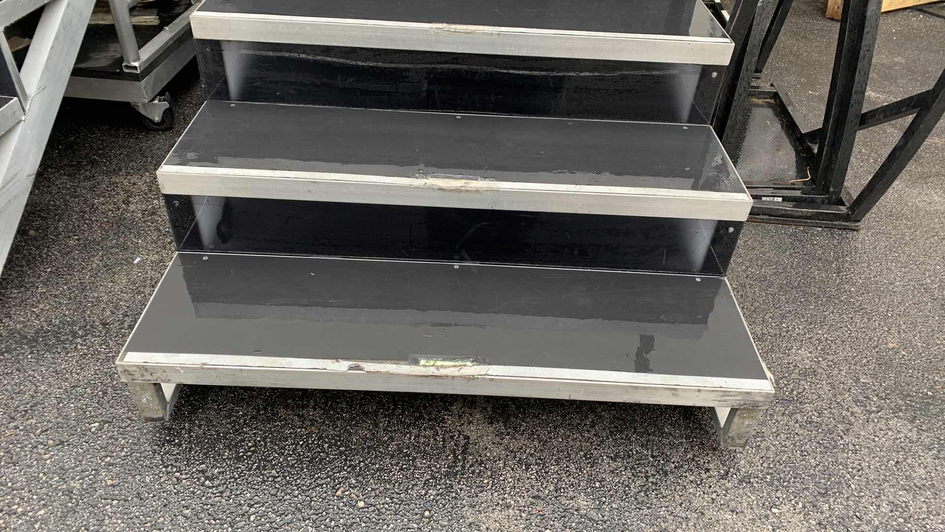 Photo 1 of ONE LARGE HEAVY DUTY ELEVEN STEP METAL AND PEXI-GLASS STAGE STAIRS WITH WHEELS W 4’ X 12’ H 7’4”