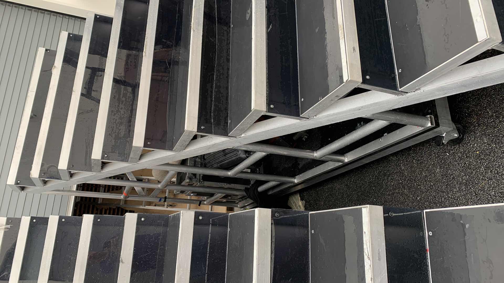 Photo 1 of ONE LARGE HEAVY DUTY ELEVEN STEP METAL AND PEXI-GLASS STAGE STAIRS WITH WHEELS 4’ X 12’ H 7’4” 