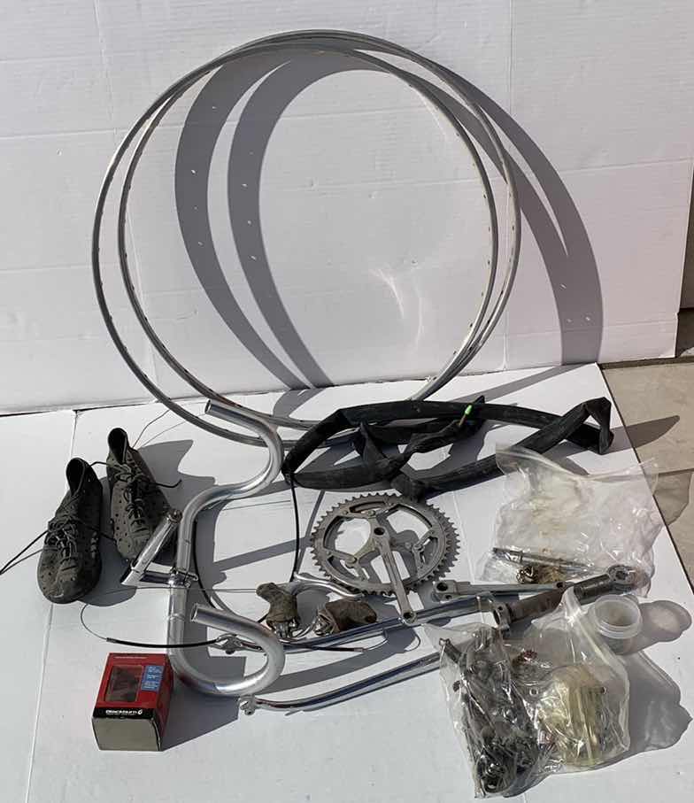 Photo 1 of ASSORTED BICYCLE PARTS AND ACCESSORIES, TO INCLUDE GEARS, BIKES SHOES SIZED 10, HANDLE BARS, RIM AND TIRE TUBES.