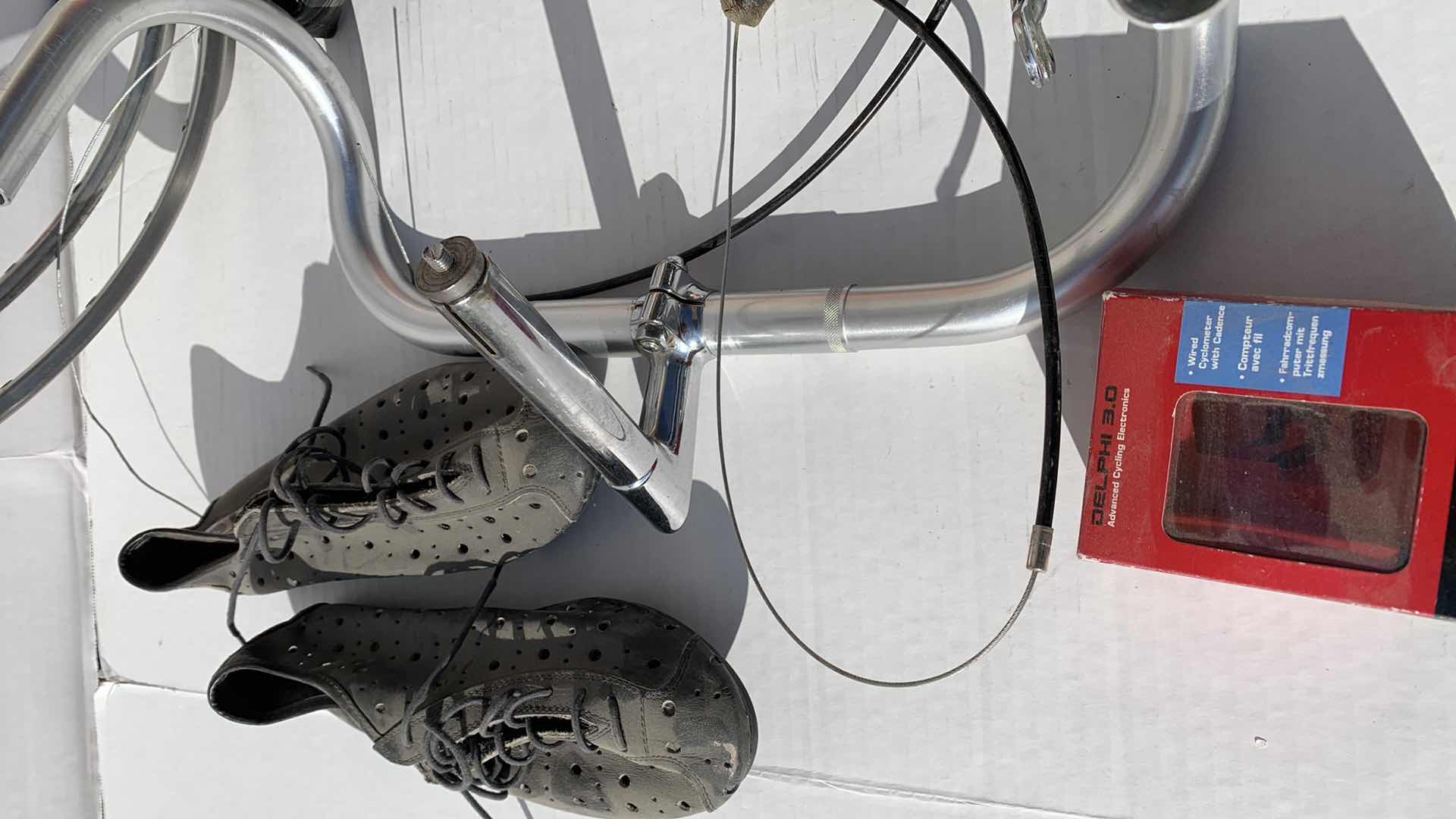 Photo 1 of ASSORTED BICYCLE PARTS AND ACCESSORIES, TO INCLUDE GEARS, BIKES SHOES SIZED 10, HANDLE BARS, RIM AND TIRE TUBES.