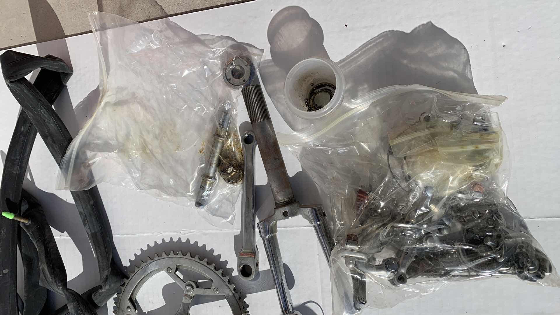 Photo 1 of ASSORTED BICYCLE PARTS AND ACCESSORIES, TO INCLUDE GEARS, BIKES SHOES SIZED 10, HANDLE BARS, RIM AND TIRE TUBES.