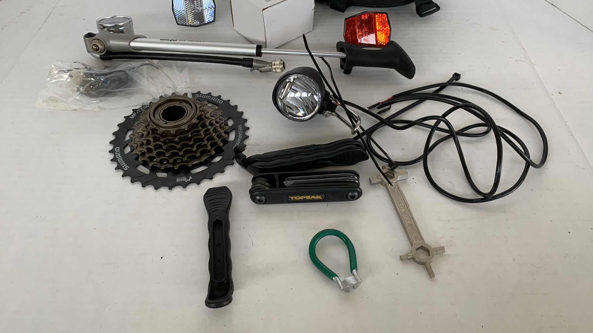 Photo 1 of ASSORTED BICYCLE PARTS AND ACCESSORIES. SPROCKET, REFLECTORS, ON PORTABLE BIKE AIR TIRE PUMP. VARIOUS TOOLS.