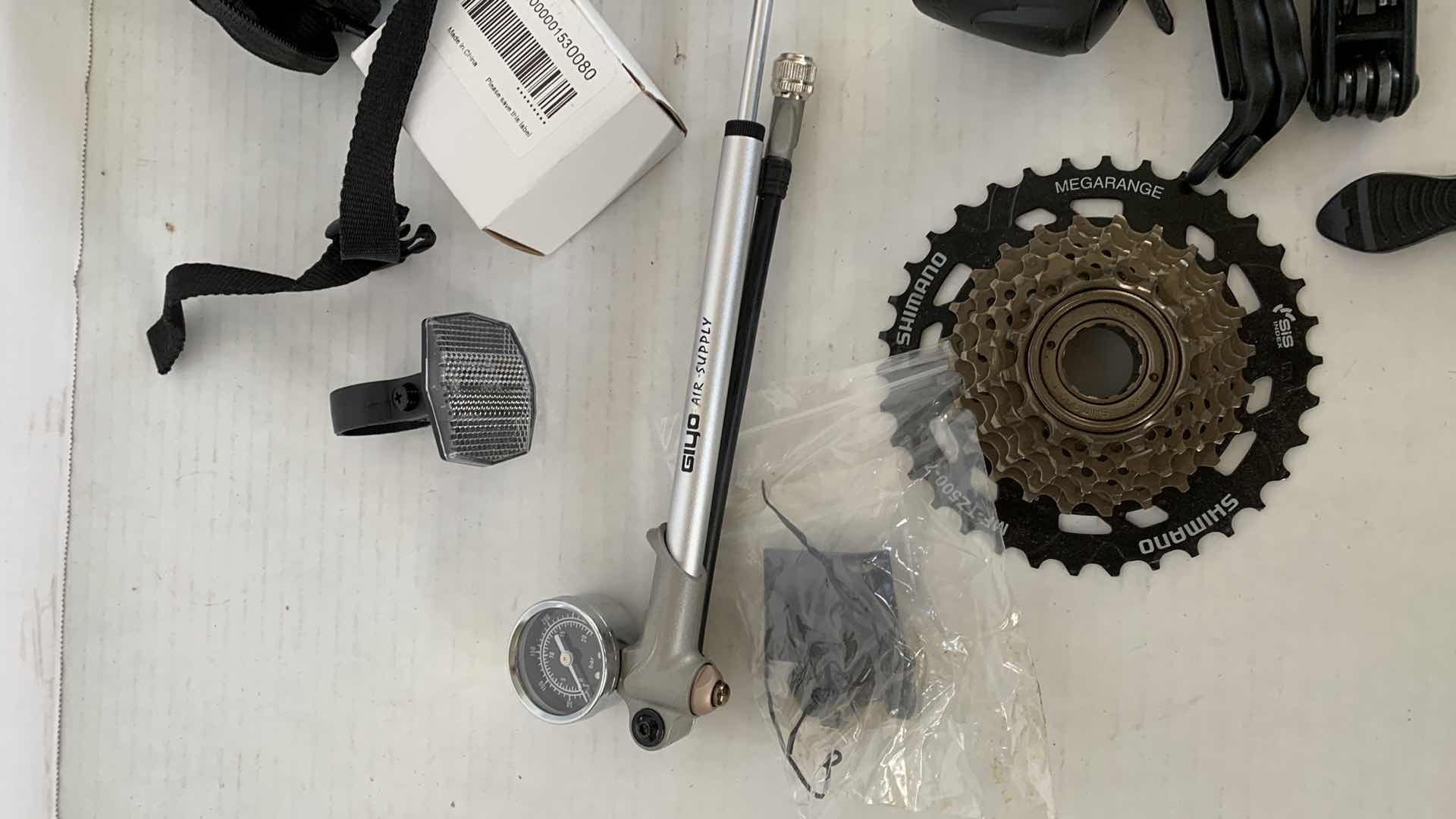 Photo 1 of ASSORTED BICYCLE PARTS AND ACCESSORIES. SPROCKET, REFLECTORS, ON PORTABLE BIKE AIR TIRE PUMP. VARIOUS TOOLS.