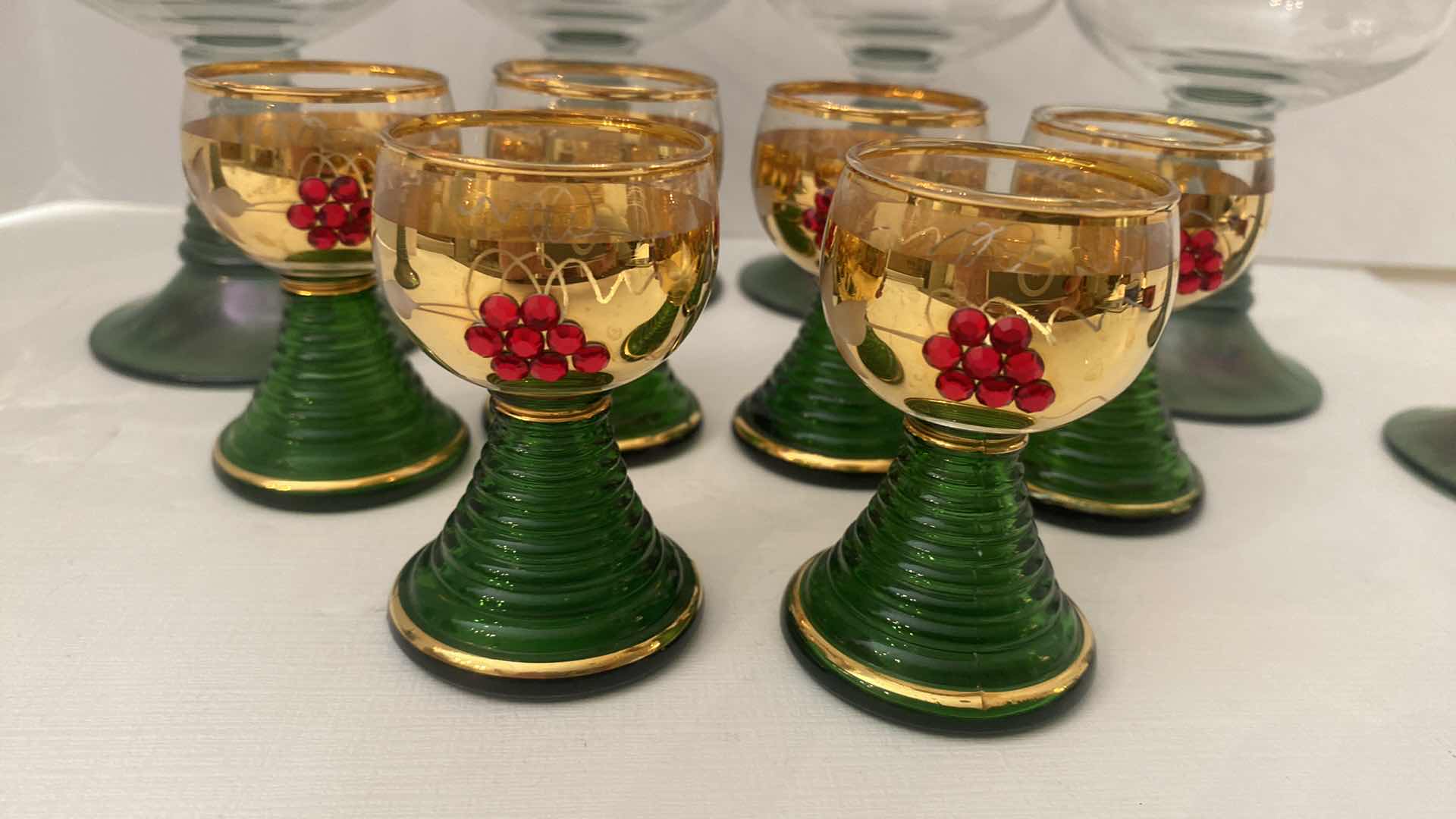 Photo 1 of VINTAGE GERMAN ROEMER GREEN AND GOLD RIMMED WINE GLASSES AND GOLD JEWELED SHOT GLASSES