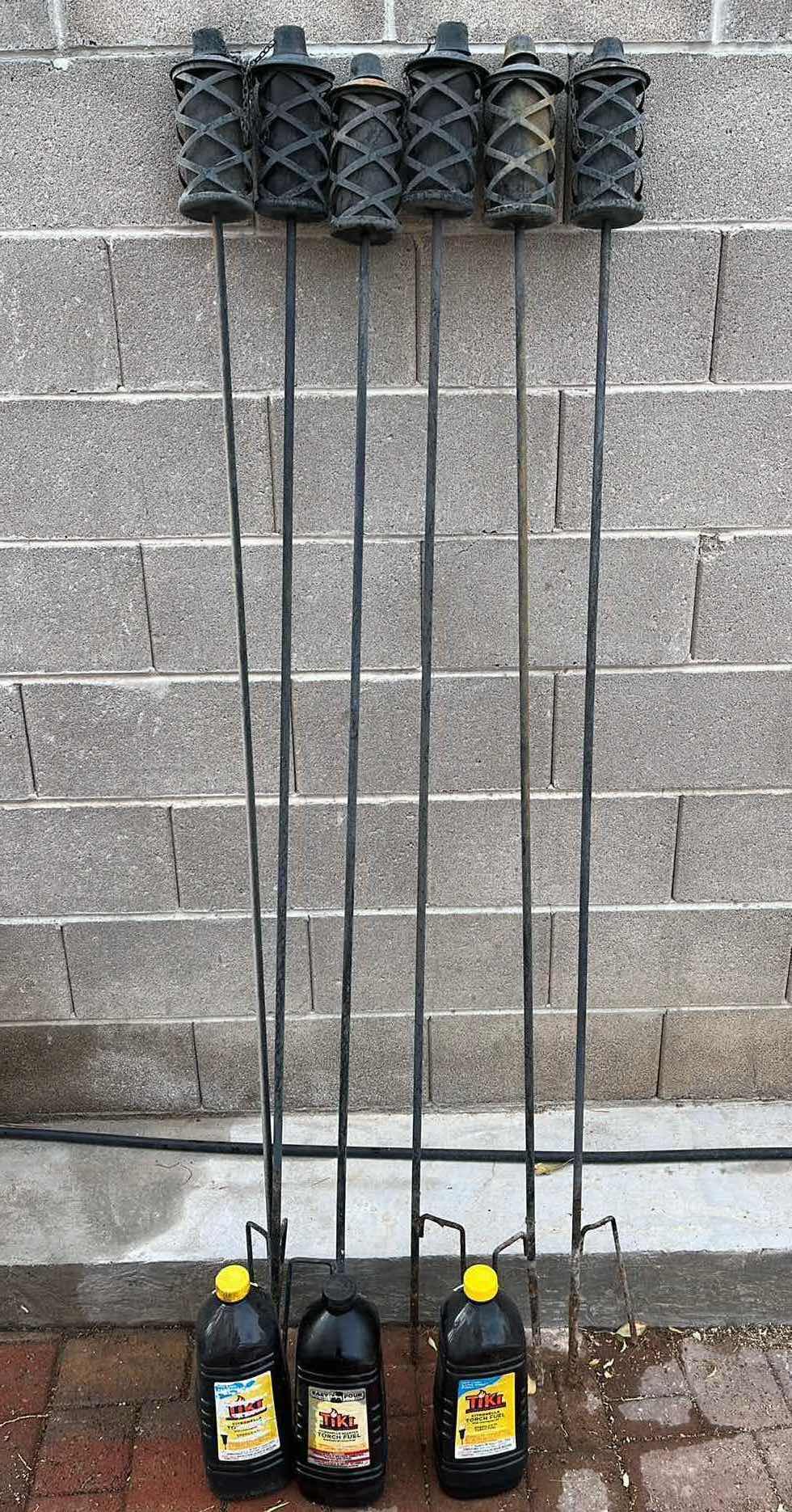 View 1 of WROUGHT IRON STYLE TIKI TORCHES (6) H72” W 3 TIKI FUEL 3QT JUGS