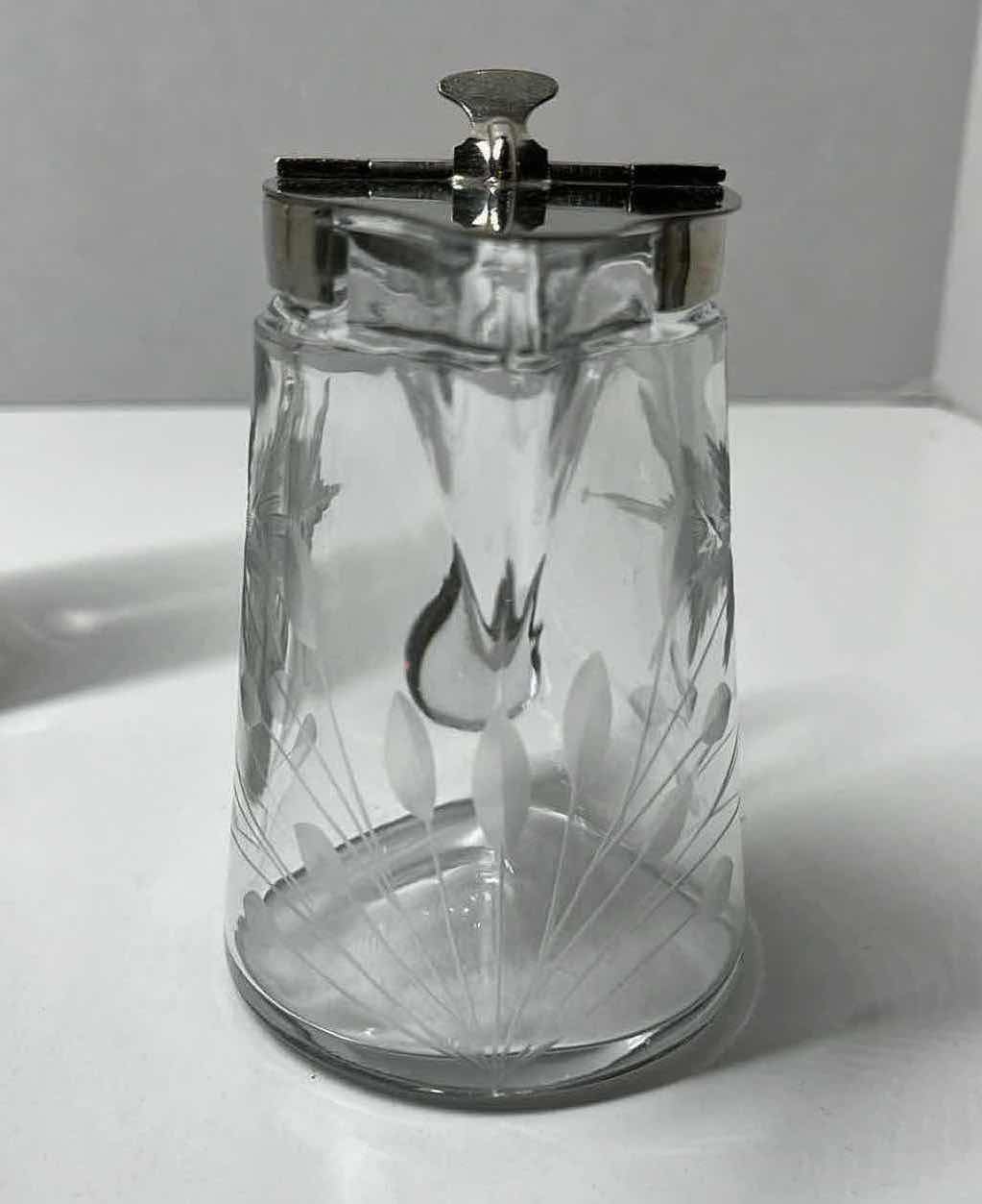 Photo 1 of ETCHED FLORAL DESIGN SYRUP DISPENSER W SPRING ACTION SILVER FINISH LID 4” X 3” H4.5”