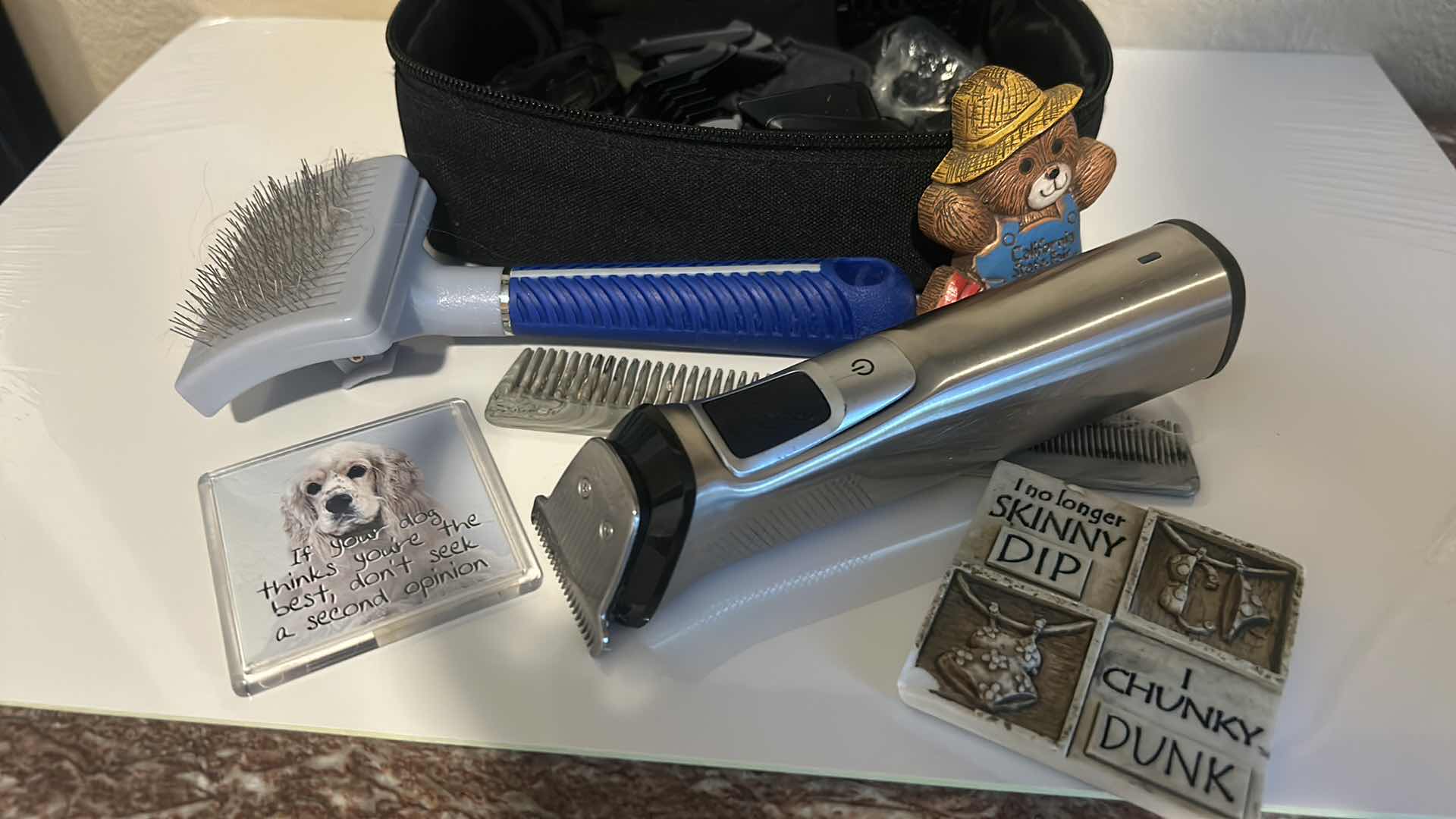 Photo 1 of DOG GROOMING ITEMS WITH CLIPPERS, BRUSHES, AND THREE MAGNETS.