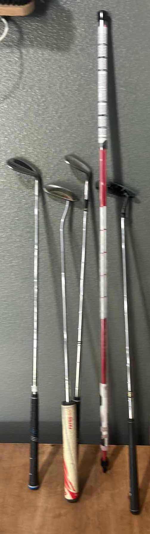 Photo 1 of FOUR GOLF CLUBS AND ONE ALIGNMENT POLE GOLF ACCESSORY.