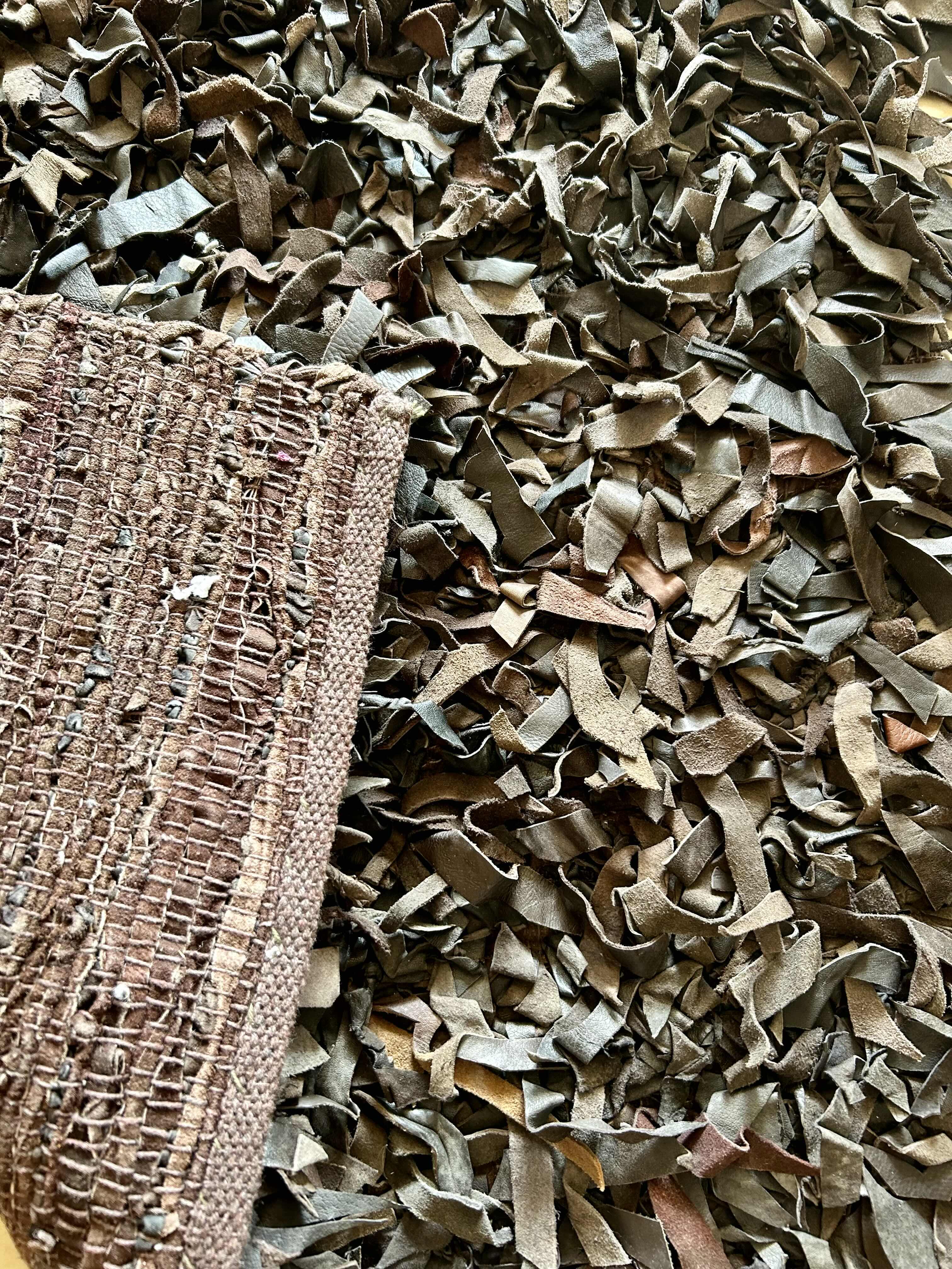 Photo 1 of 30” X 51” VARIEGATED BROWN  LEATHER SHAG RUG 
RETAIL: $200.00