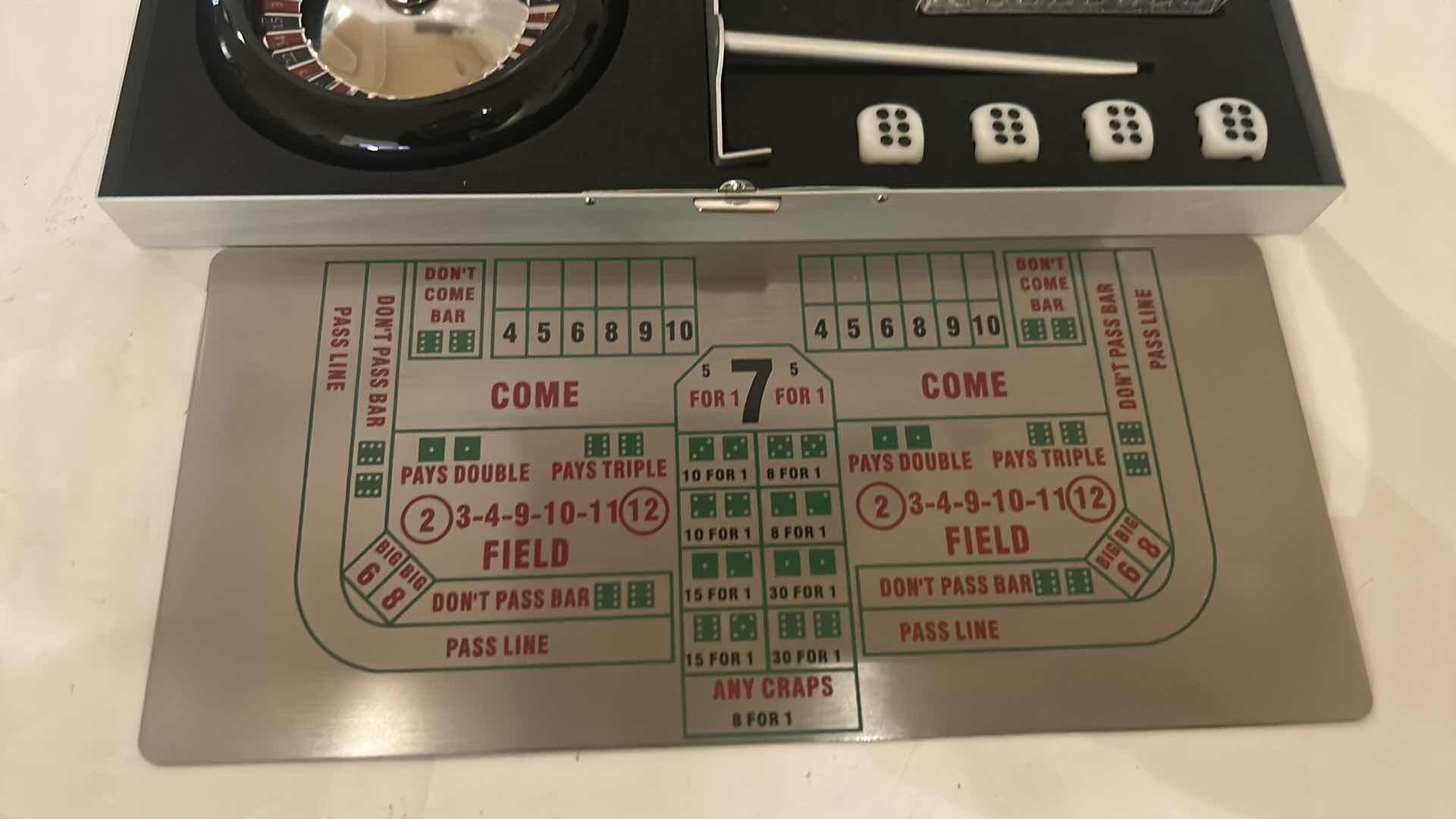 Photo 1 of MINIATURE GAMBLING SET IN METAL BOX, INCLUDING ROULETTE, CRAPS, AND BLACKJACK. 9” x H4 1/4”