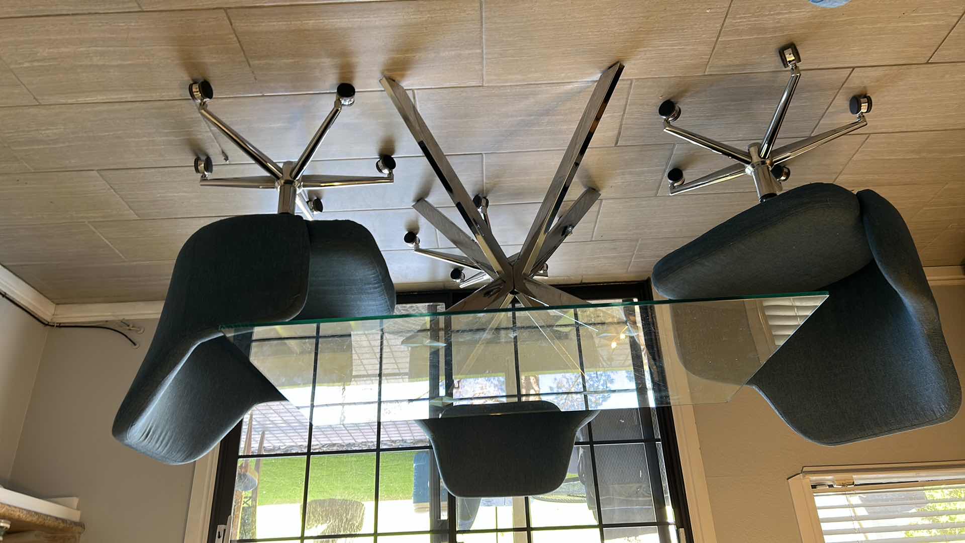 Photo 1 of GLASS TOP DINING TABLE W SILVER CHROME LEGGS  4- SWIVEL BLUE FABRIC CHAIRS CHROME LEGGS ON WHEELS