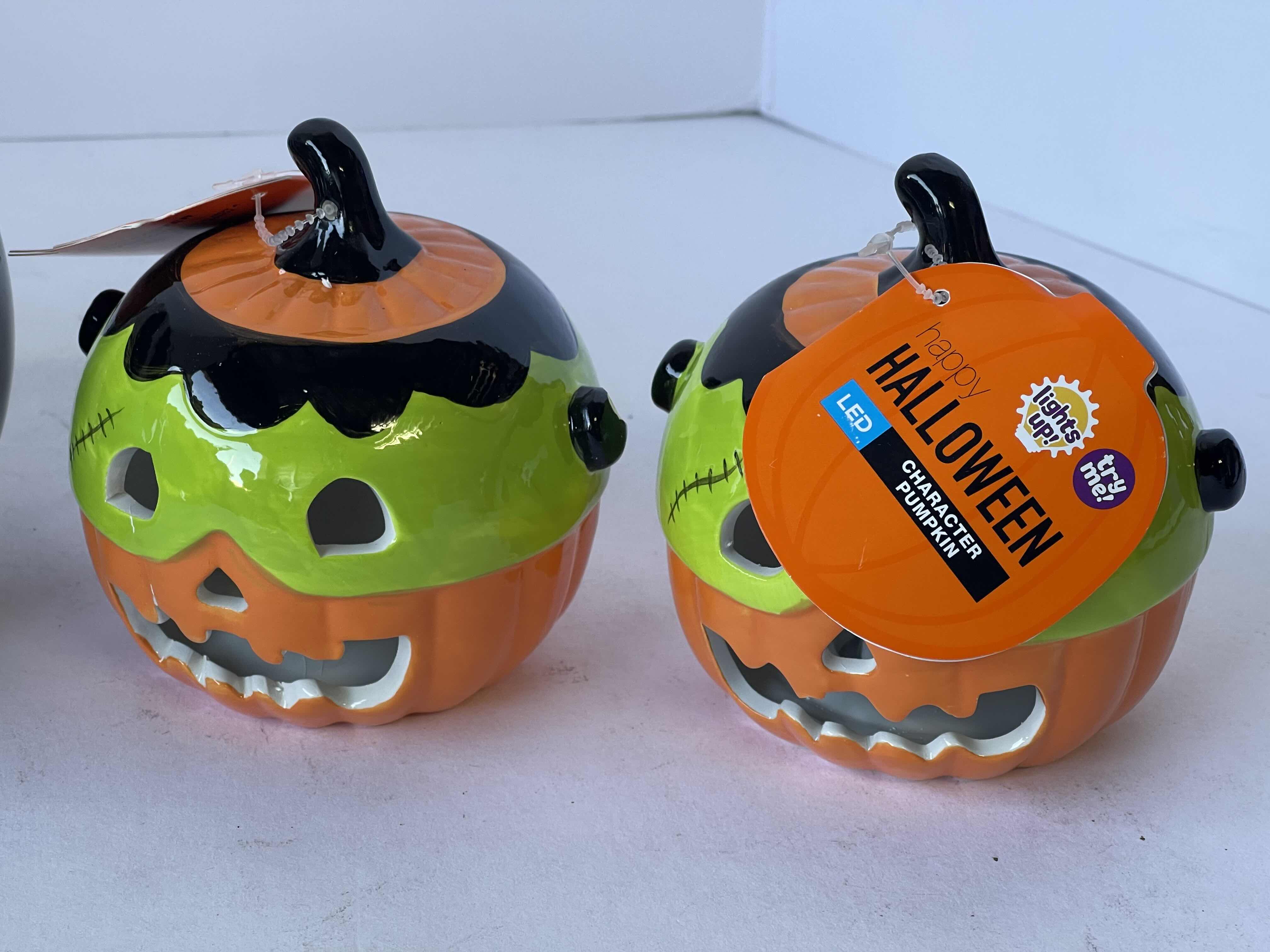 Photo 1 of HAPPY HALLOWEEN 4” MINI CERAMIC LIGHT UP PUMPKINS (4) & BLACK 6” SKELETON HAND PUMPKIN