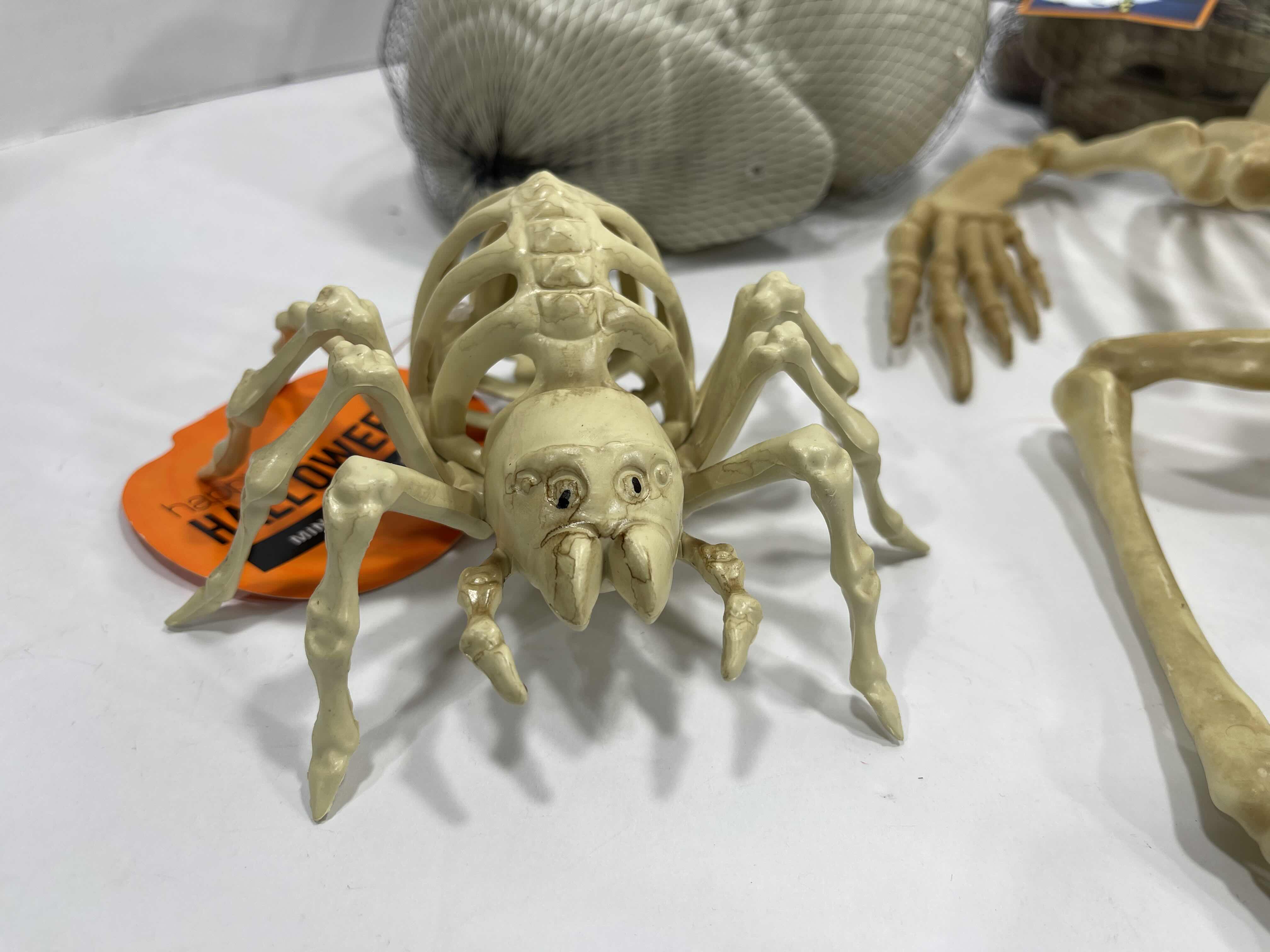 Photo 1 of HALLOWEEN YARD SKELETON DECORATIONS ASSORTED LOT (5 ITEMS) - BAG OF BONES, SKULL HEADS, LIGHT-UP SKELETON FROG & MINI SKELETONS (2) MSRP $50