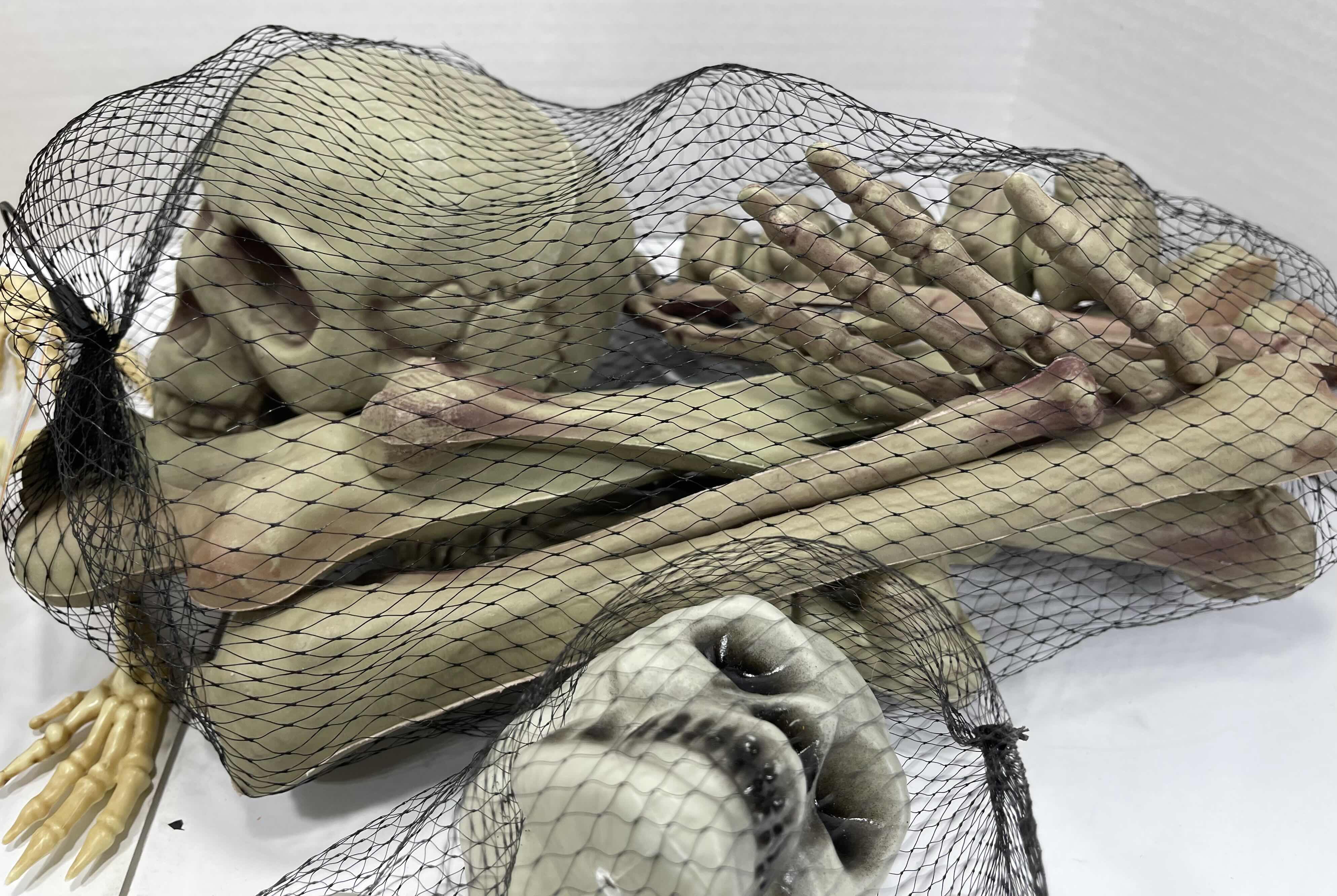 Photo 1 of HALLOWEEN YARD SKELETON DECORATIONS ASSORTED LOT (5 ITEMS) - BAG OF BONES, BAG OF SKULL HEADS (2), LIGHT-UP SKELETON FROG & MINI SKELETON MSRP $50