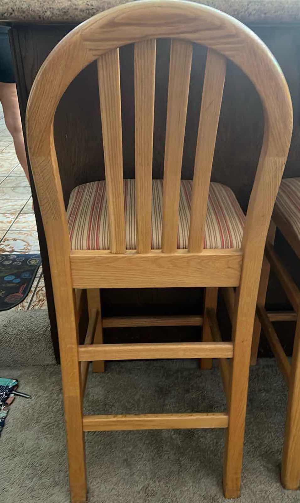Photo 1 of 24” COUNTER HEIGHT WOODEN BAR STOOLS. TAN AND RED UPHOLSTERED SEAT CUSHIONS.
