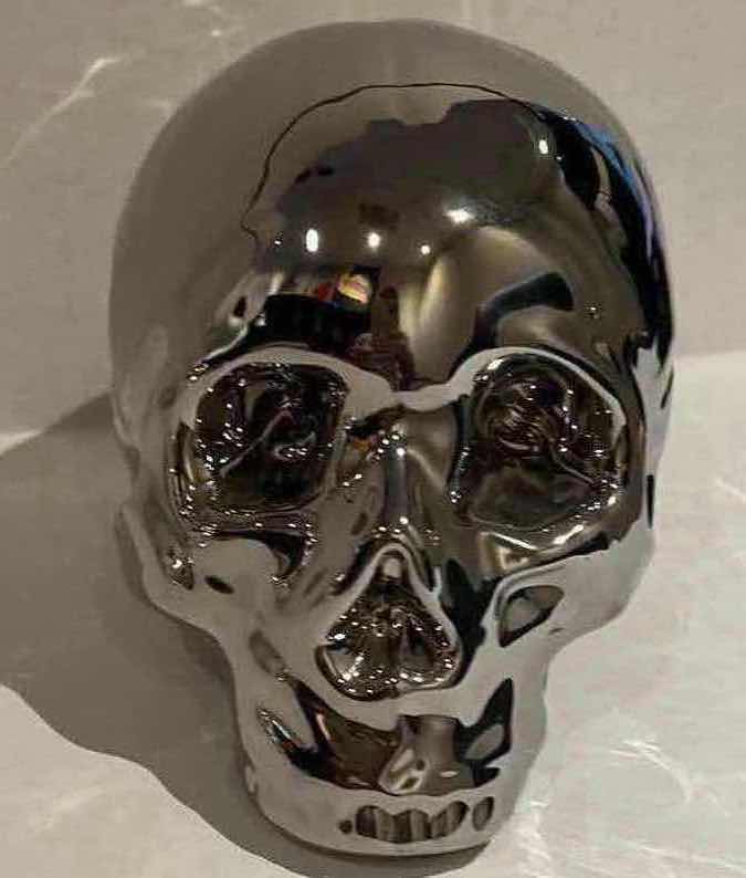 Photo 1 of 2-SILVER CERAMIC SKULLS. SMALLER ONE IS A PIGGY BANK, H5” LARGER SKULL LIGHTS UP, H6”