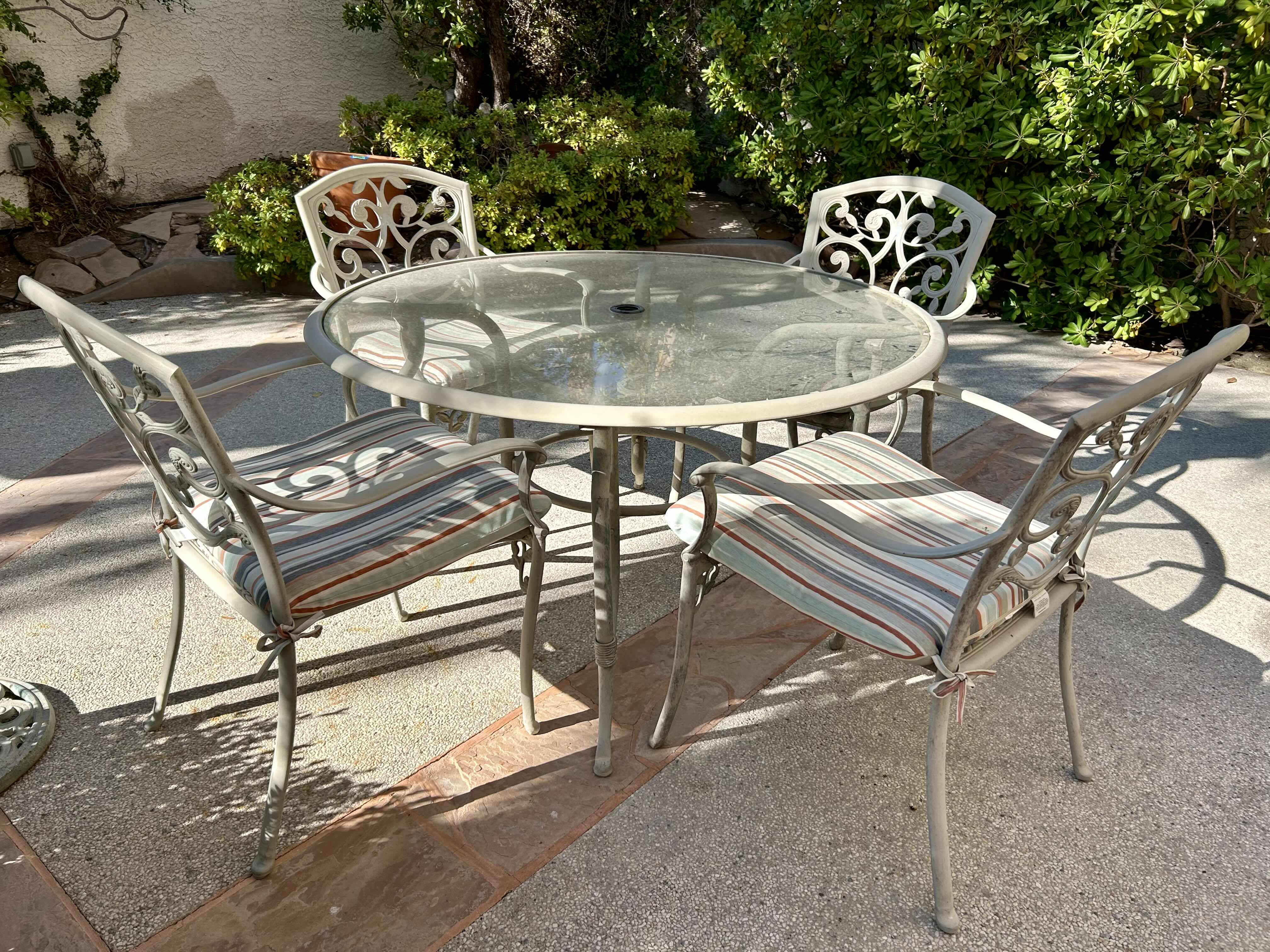 Photo 1 of 50” METAL PATIO TABLE SET WITH GLASS TOP AND 4 CHAIRS WITH STRIPED CUSHIONS