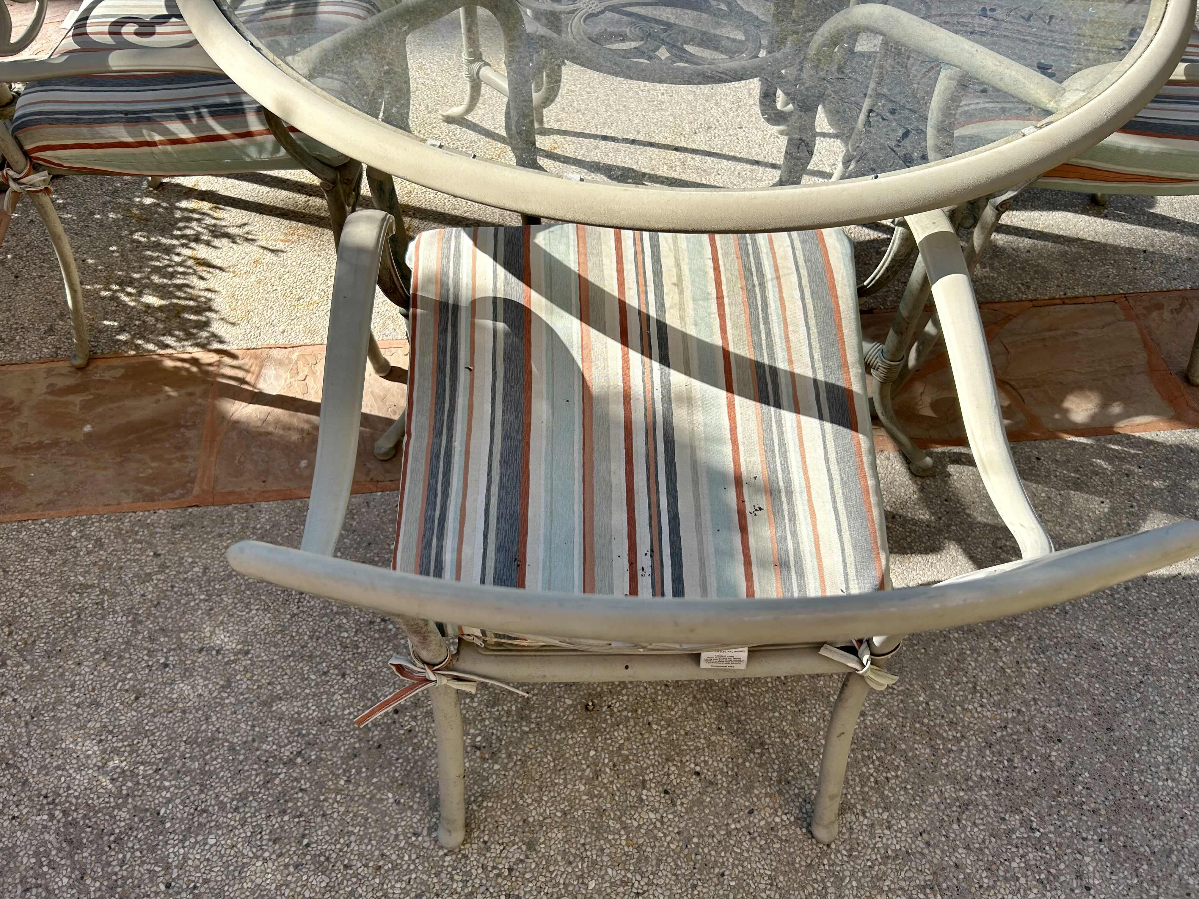 Photo 1 of 50” METAL PATIO TABLE SET WITH GLASS TOP AND 4 CHAIRS WITH STRIPED CUSHIONS