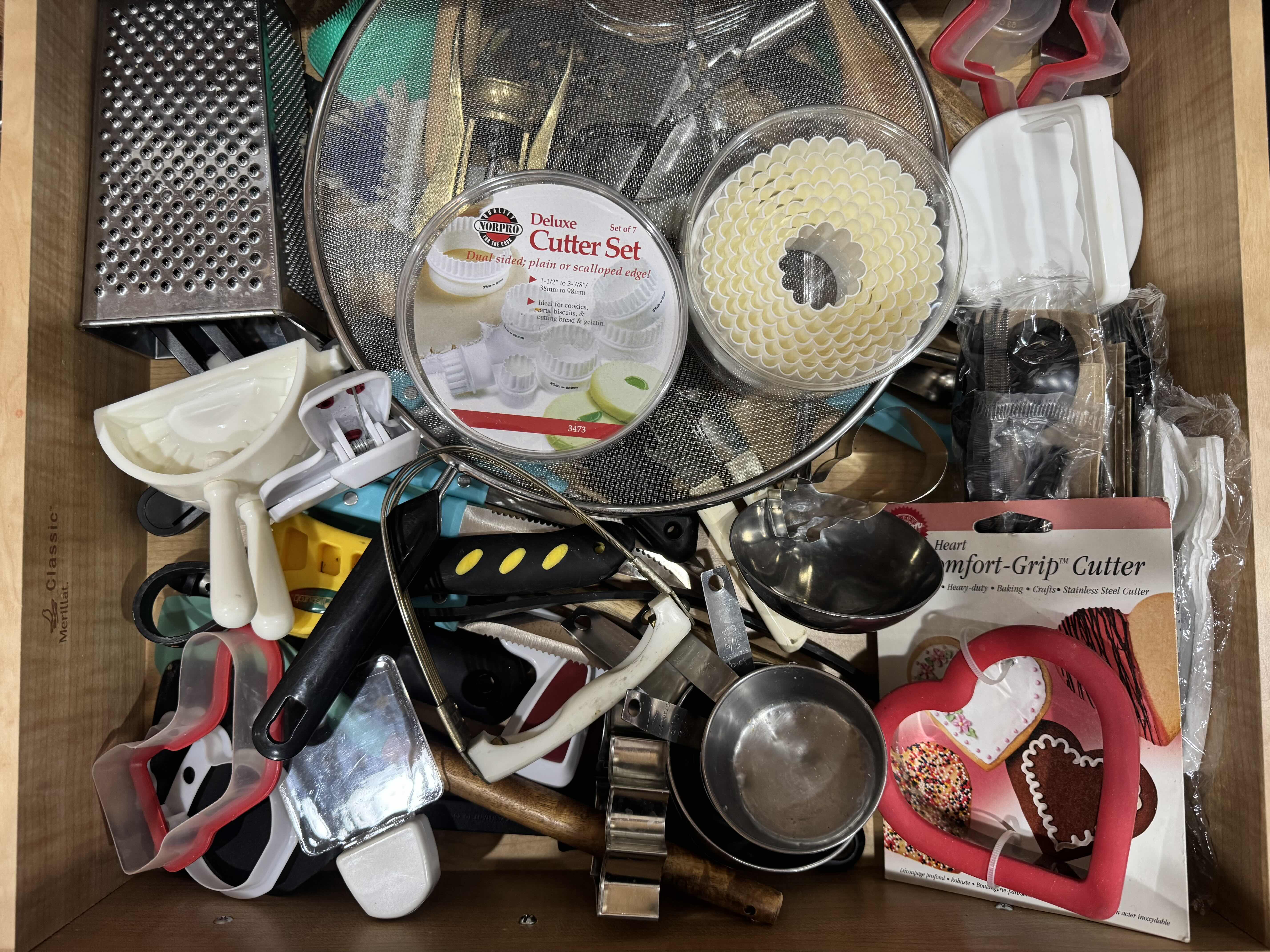 Photo 1 of CONTENTS OF KITCHEN DRAWER, BAKING AND COOKING ACCESSORIES. COOKIE CUTTERS, CHEESE GRATER, MEASURING CUPS ETC...