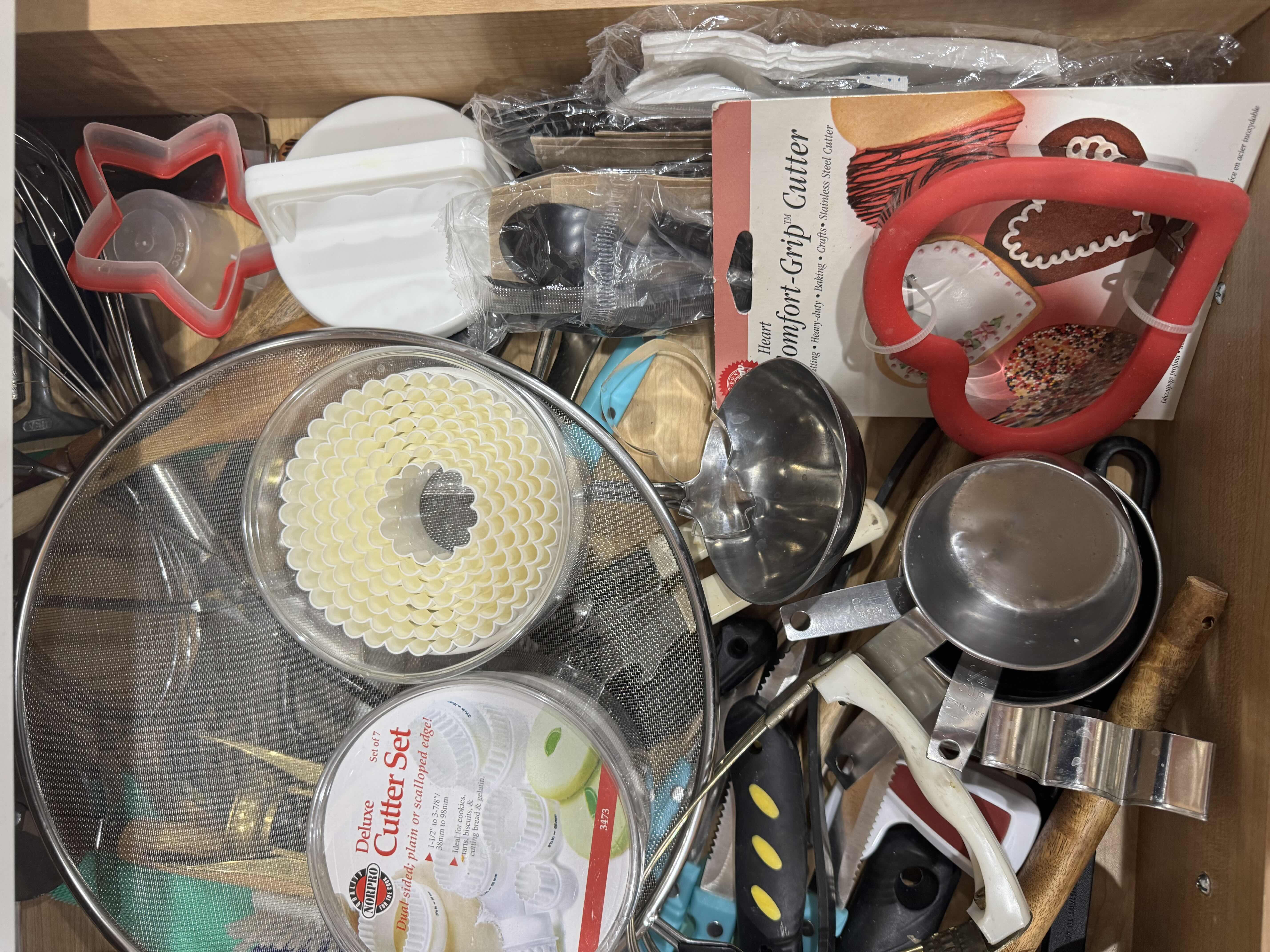 Photo 1 of CONTENTS OF KITCHEN DRAWER, BAKING AND COOKING ACCESSORIES. COOKIE CUTTERS, CHEESE GRATER, MEASURING CUPS ETC...