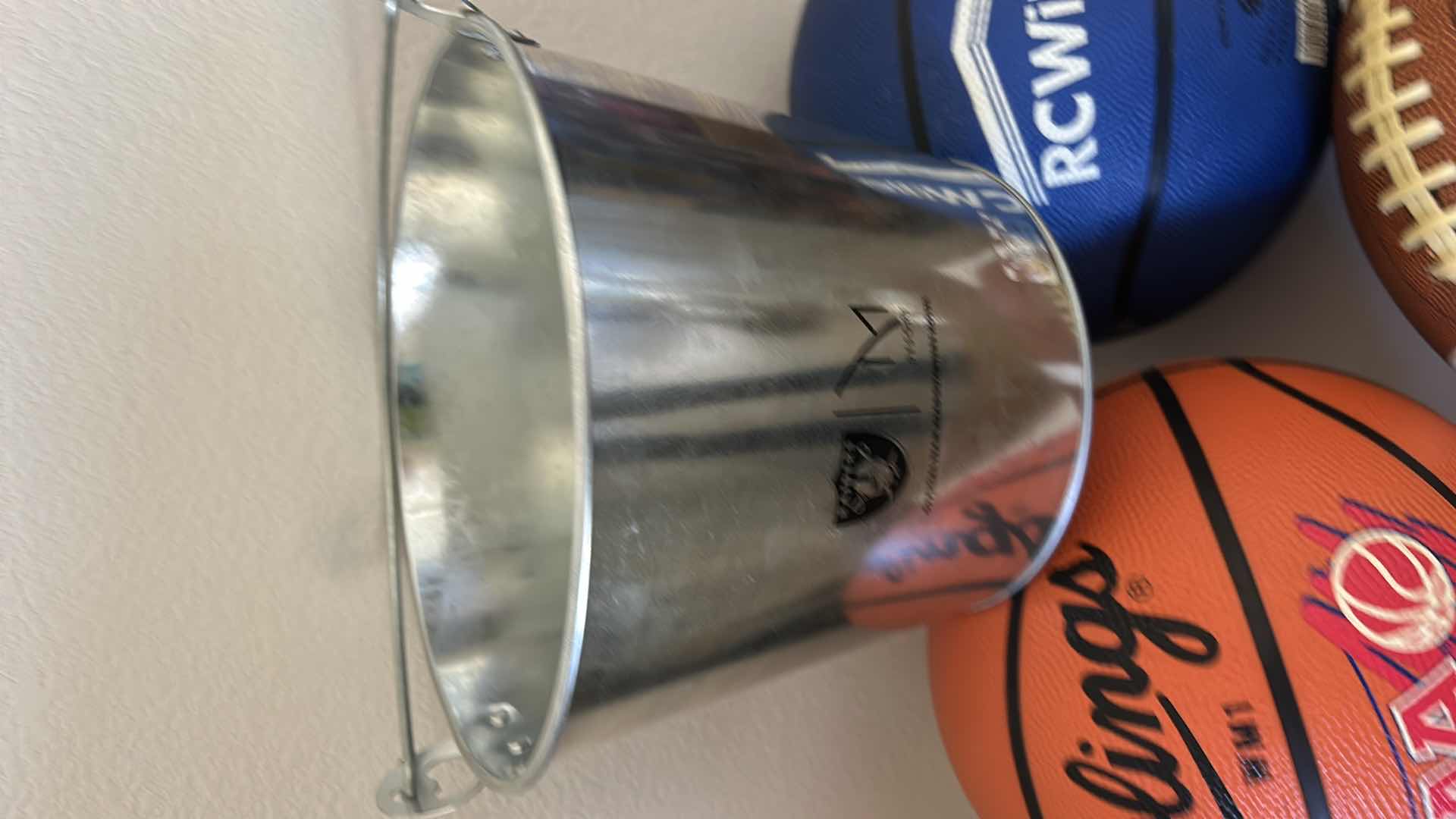 Photo 1 of 2 BASKETBALLS, FOOTBALL AND RAIDERS BUCKET