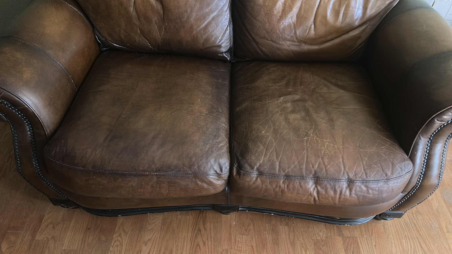 Photo 1 of BROWN LEATHER LOVESEAT WITH NAIL HEAD TRIM AND WOOD BASE & LEGS  69“ x 39“ x H36“