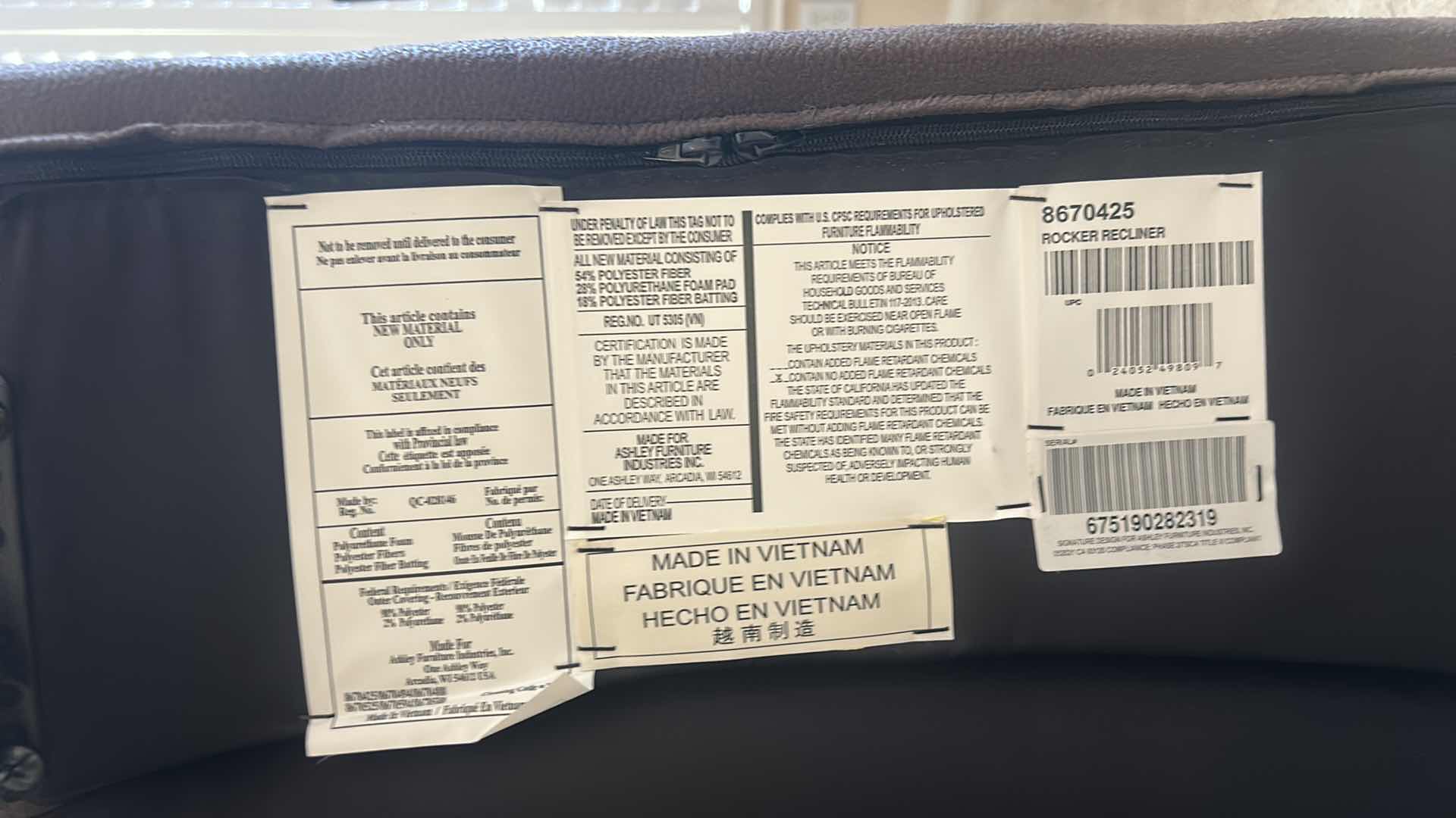 Photo 1 of ASHLEY FURNITURE ROCKER RECLINER WITH LEATHER-LOOK UPHOLSTERY. MADE OF POLYURETHANE, POLYESTER, AND FIBER MATERIALS.