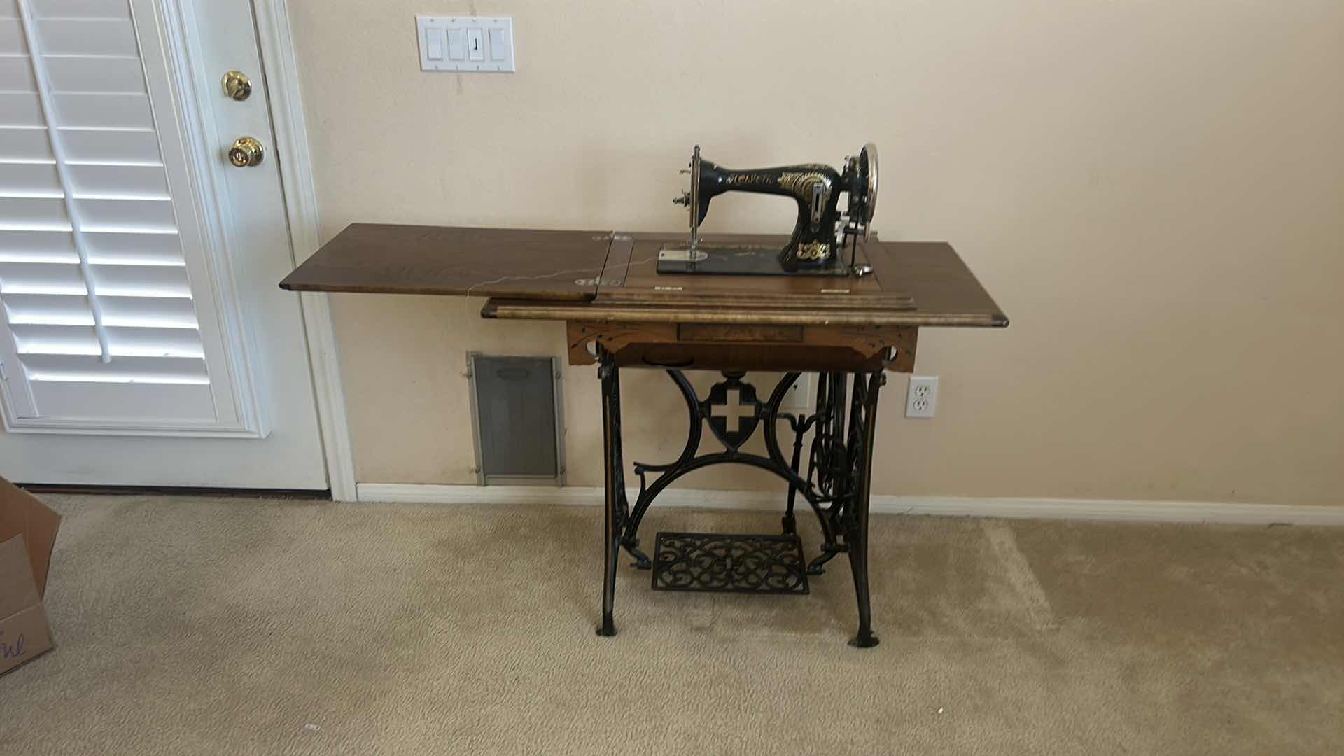Photo 1 of ANTIQUE HELVETIA TREADLE SEWING MACHINE AND CABINET, ORNATE CAST IRON AND GOLD DETAILING PLUS PARTS. INCLUDES CAST IRON TREADLE BASE, SEWING MACHINE HEAD, WOOD TABLE TOP, DRAWERS, AND LOOSE WOOD COMPONENTS. 
36 1/2“ x 18 1/2“ x H32“