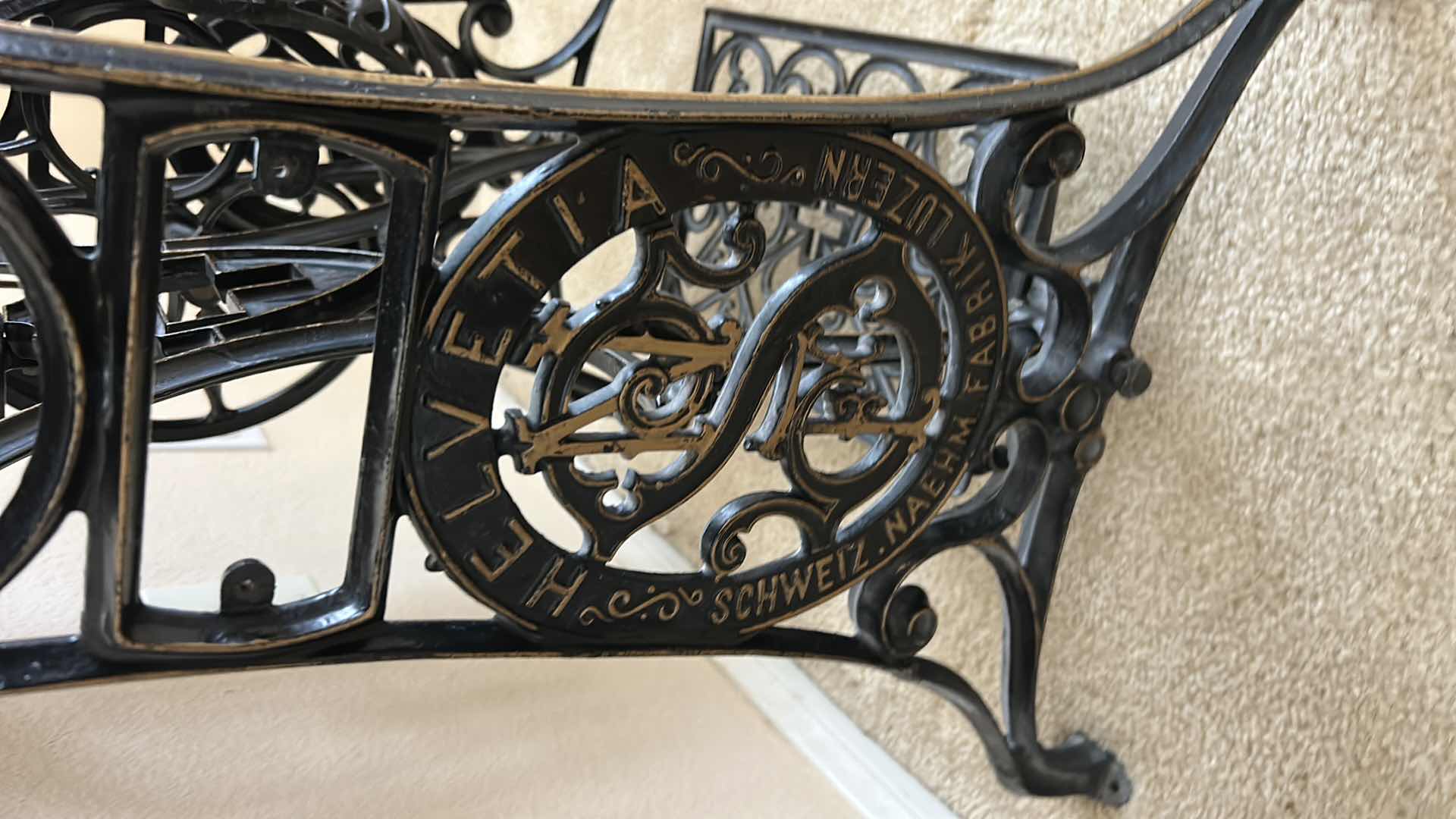 Photo 1 of ANTIQUE HELVETIA TREADLE SEWING MACHINE AND CABINET, ORNATE CAST IRON AND GOLD DETAILING PLUS PARTS. INCLUDES CAST IRON TREADLE BASE, SEWING MACHINE HEAD, WOOD TABLE TOP, DRAWERS, AND LOOSE WOOD COMPONENTS. 
36 1/2“ x 18 1/2“ x H32“