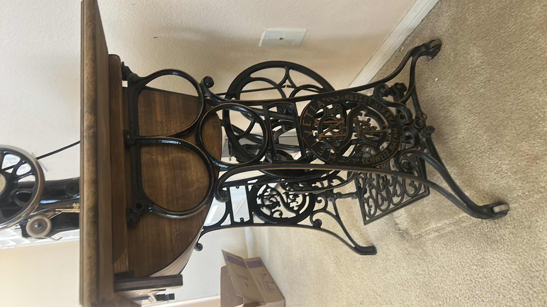 Photo 1 of ANTIQUE HELVETIA TREADLE SEWING MACHINE AND CABINET, ORNATE CAST IRON AND GOLD DETAILING PLUS PARTS. INCLUDES CAST IRON TREADLE BASE, SEWING MACHINE HEAD, WOOD TABLE TOP, DRAWERS, AND LOOSE WOOD COMPONENTS. 
36 1/2“ x 18 1/2“ x H32“
