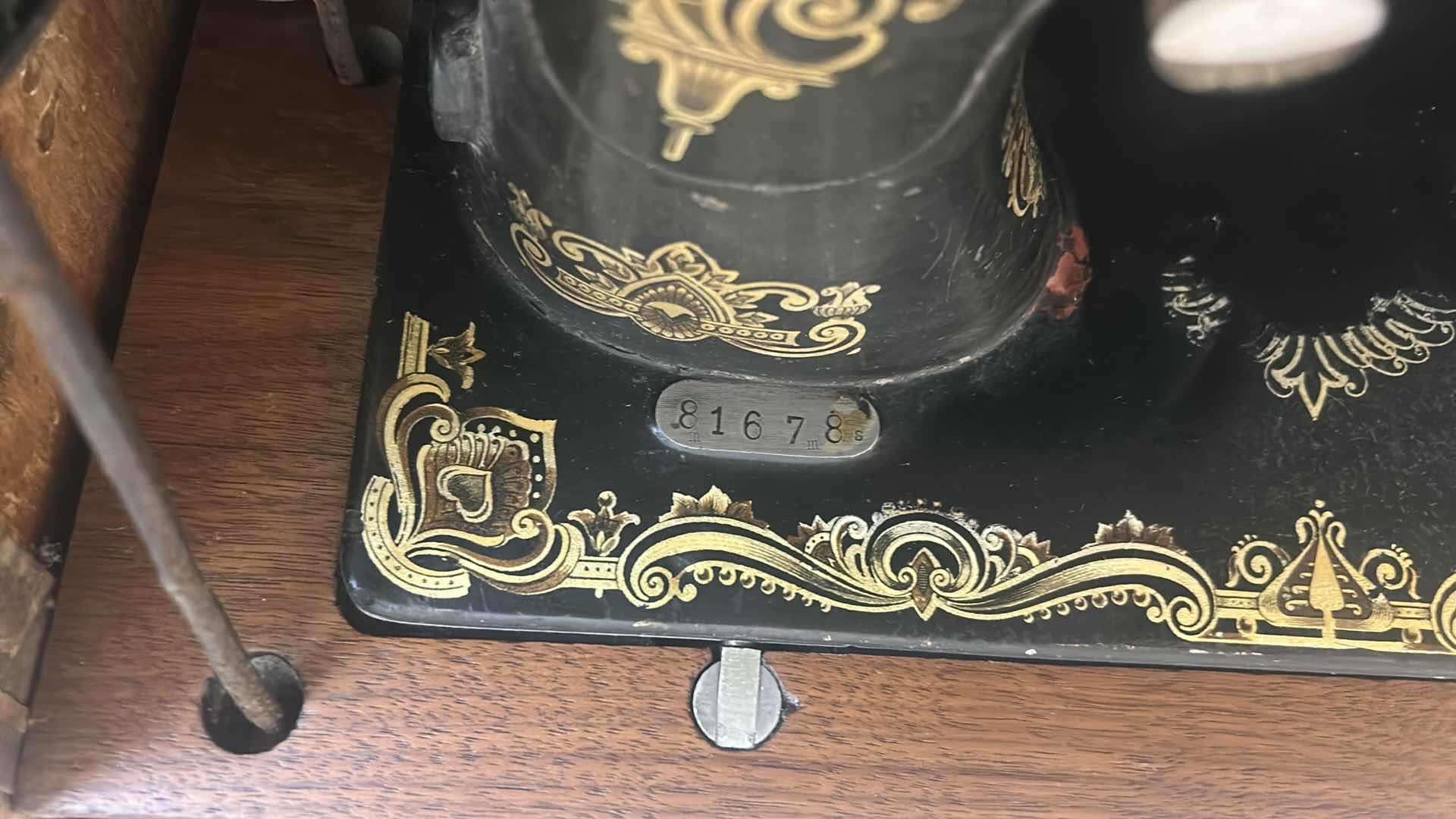 Photo 1 of ANTIQUE HELVETIA TREADLE SEWING MACHINE AND CABINET, ORNATE CAST IRON AND GOLD DETAILING PLUS PARTS. INCLUDES CAST IRON TREADLE BASE, SEWING MACHINE HEAD, WOOD TABLE TOP, DRAWERS, AND LOOSE WOOD COMPONENTS. 
36 1/2“ x 18 1/2“ x H32“