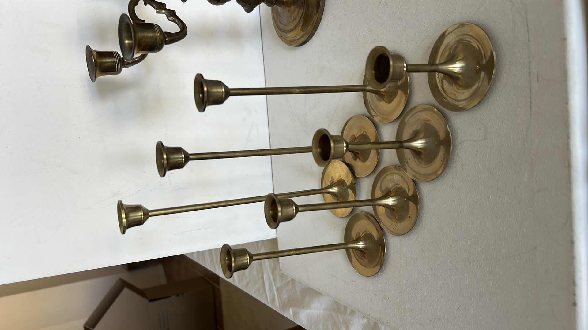 Photo 1 of BRASS CANDLE HOLDERS AND CANDLE ACCESSORIES. INCLUDES MULTIPLE TALL TAPER HOLDERS, A MULTI-ARM CANDELABRA H10” AND A BRASS CUP.