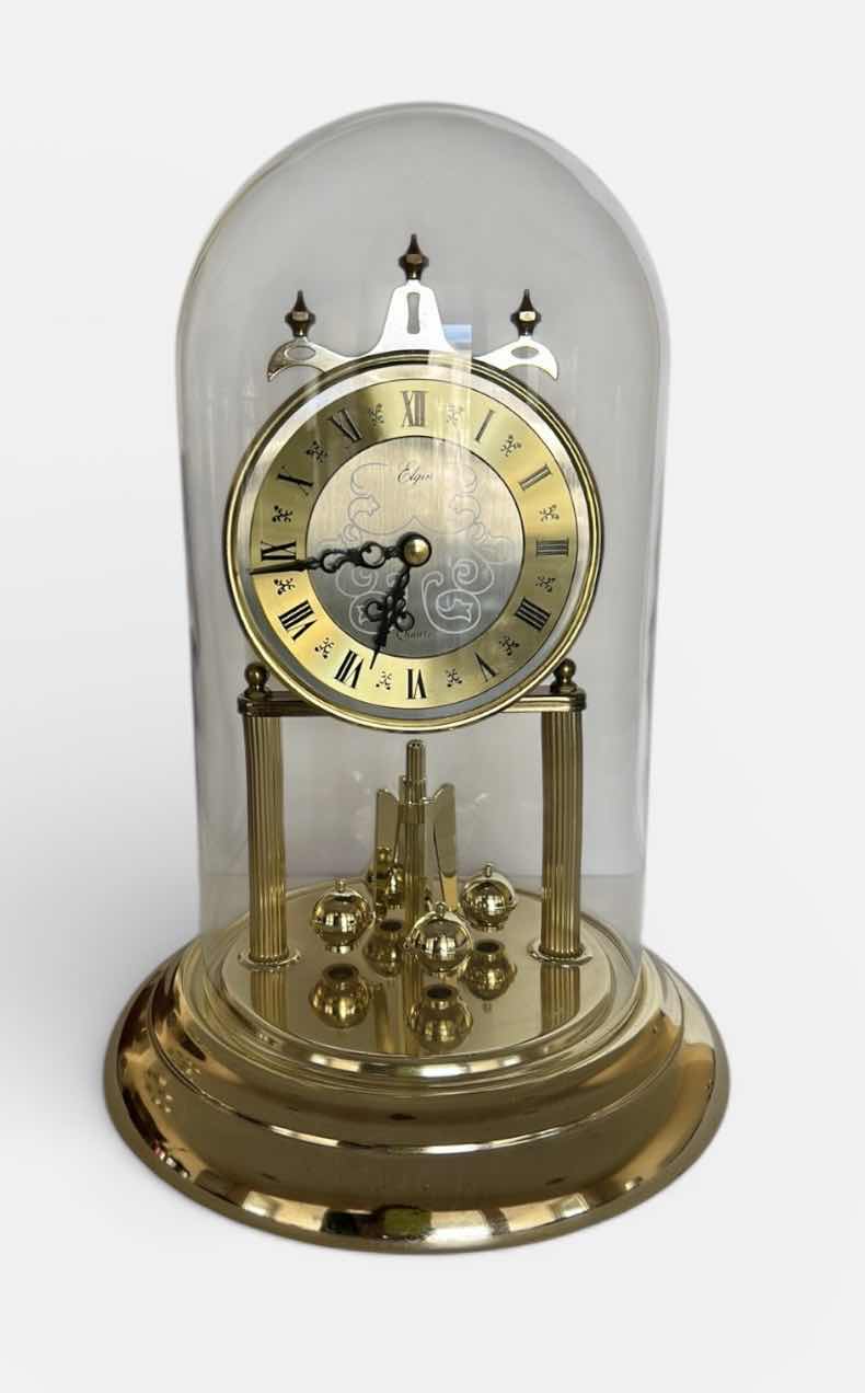 Photo 1 of ELGIN QUARTZ ANNIVERSARY CLOCK WITH GLASS DOME. BRASS-TONE FRAME WITH ROUND CLOCK FACE AND ROTATING PENDULUM BALLS. H12”