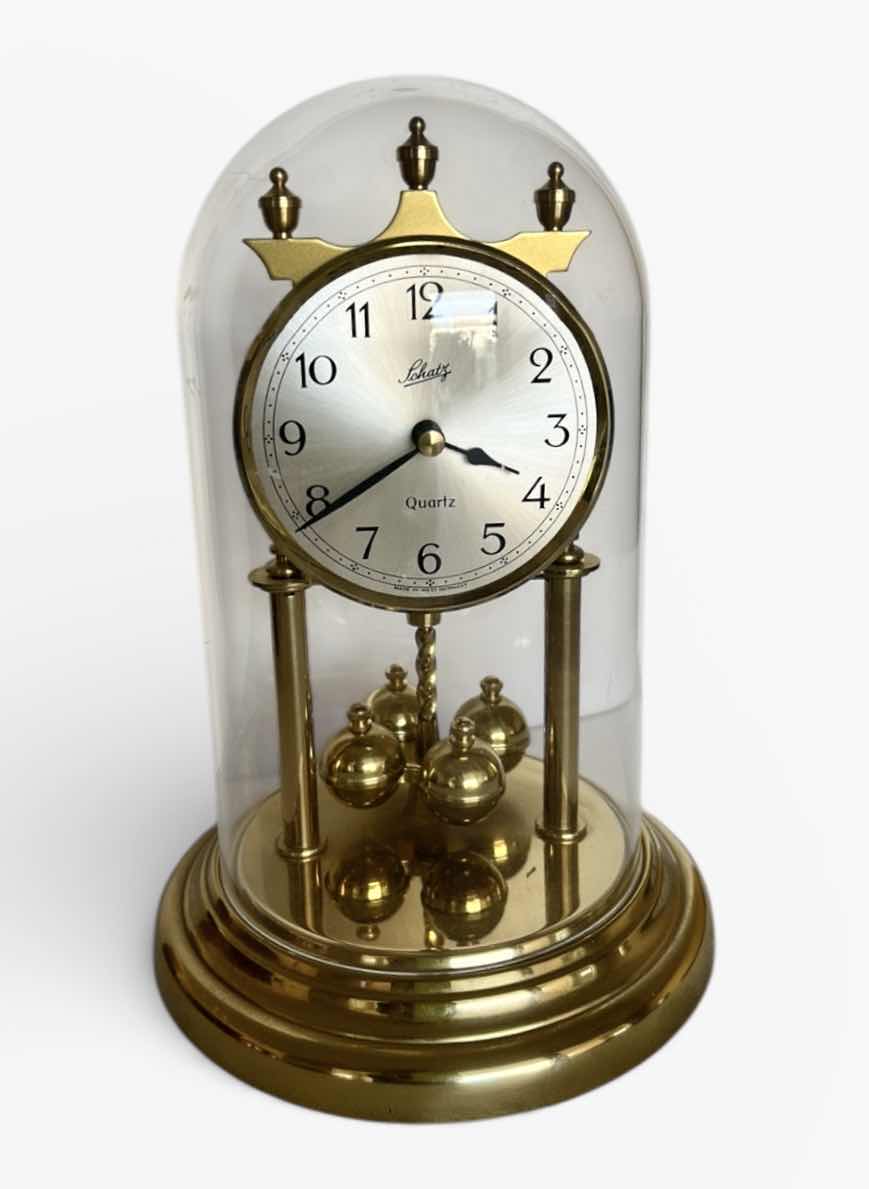 Photo 1 of SCHATZ QUARTZ ANNIVERSARY CLOCK WITH GLASS DOME. BRASS-TONE FRAME WITH ROTATING PENDULUM BALLS AND ROUND CLOCK FACE H 9 1/2”