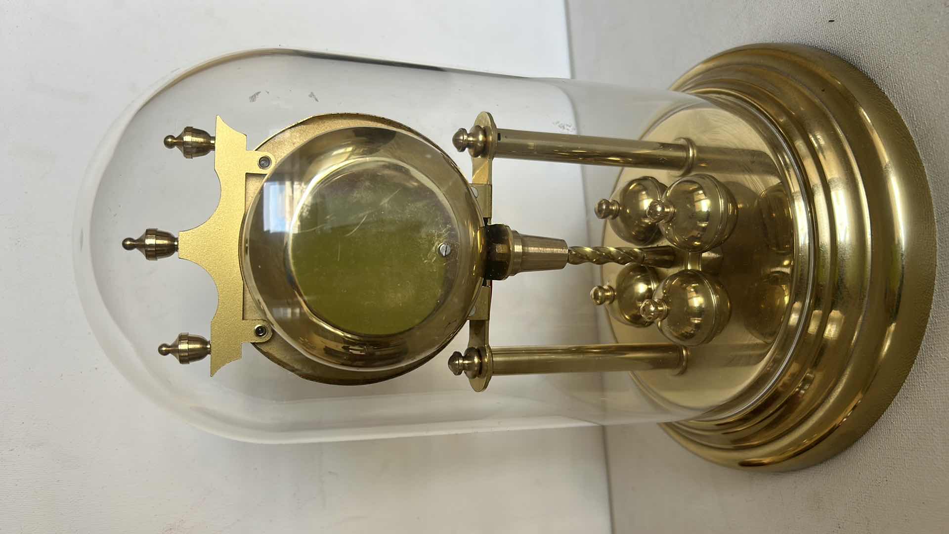 Photo 1 of SCHATZ QUARTZ ANNIVERSARY CLOCK WITH GLASS DOME. BRASS-TONE FRAME WITH ROTATING PENDULUM BALLS AND ROUND CLOCK FACE H 9 1/2”
