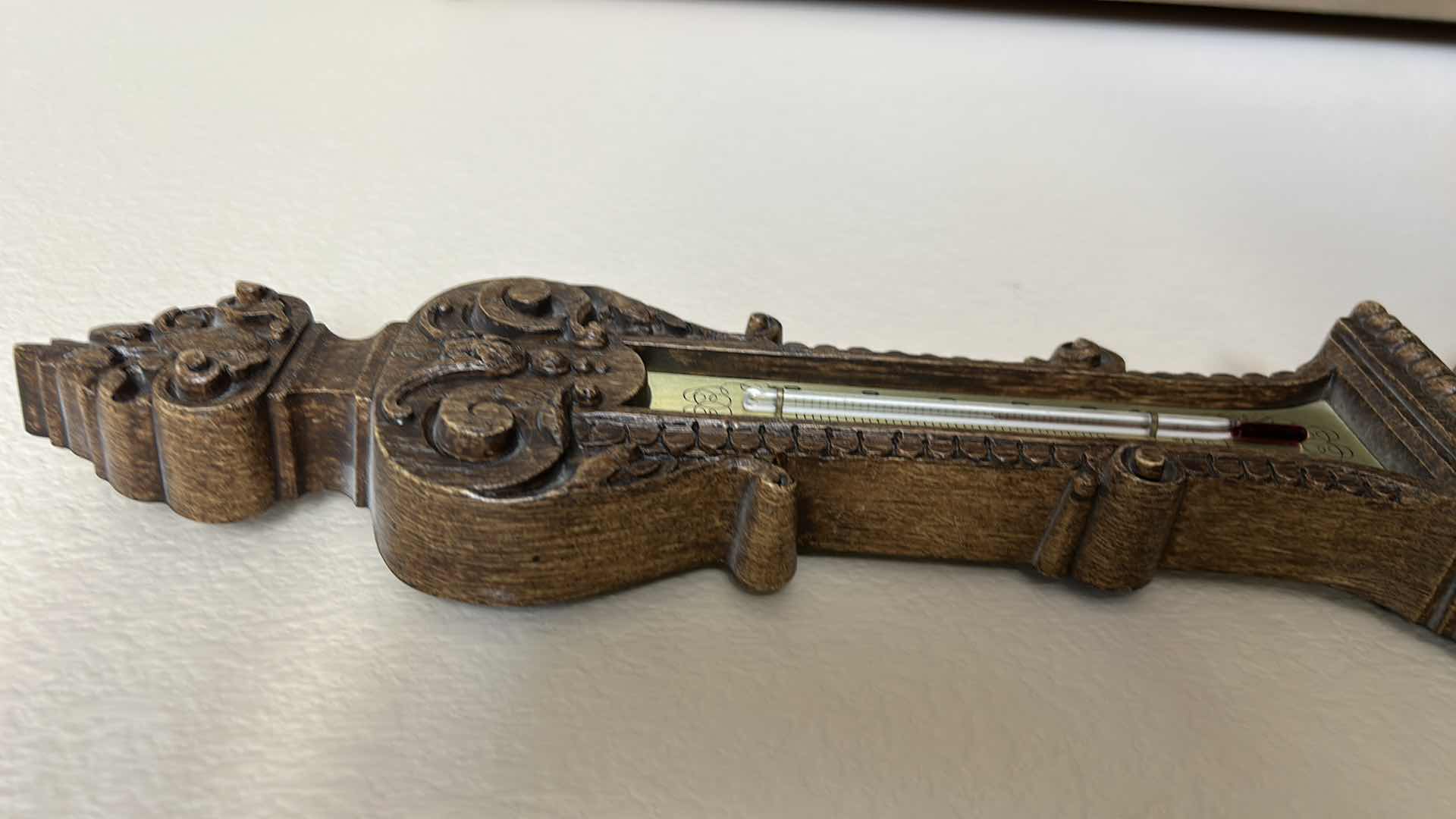 Photo 1 of ANTIQUE STYLE WALL-MOUNTED BAROMETER AND THERMOMETER. ORNATE DECORATIVE FRAME WITH ROUND DIAL AND VERTICAL TEMPERATURE GAUGE. RESIN H30’