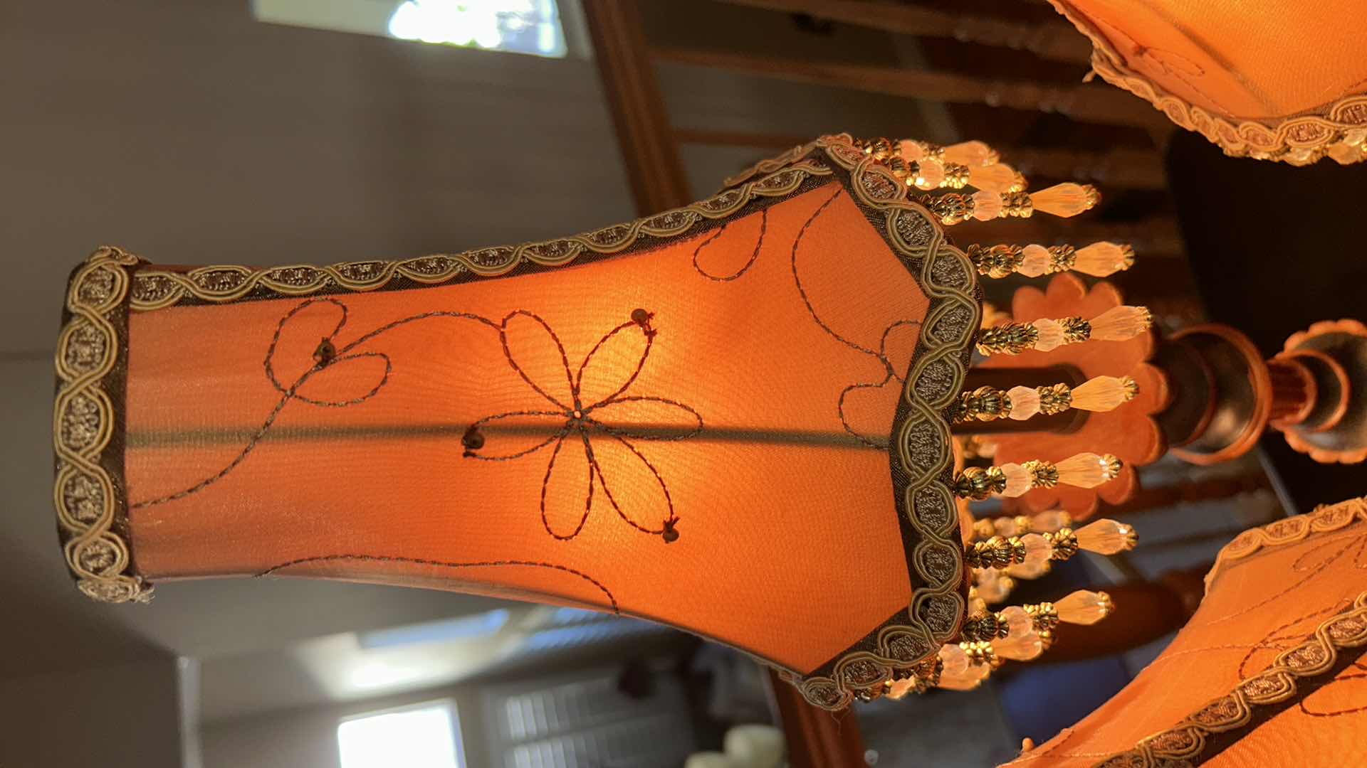 Photo 1 of THREE-LIGHT TABLE LAMP WITH METAL BASE AND SCROLL ARMS, ORANGE FABRIC SHADES WITH BEADED FRINGE H29.5”