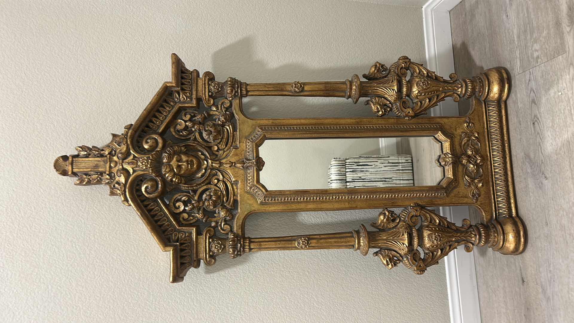 Photo 1 of ITALIAN BAROQUE-STYLE FIGURAL MIRROR FEATURING A GOLD GILT FINISH, A LARGE CENTRAL FEMALE FACE CREST, AND WINGED GRIFFINS ON THE BASE. 25” x H53“