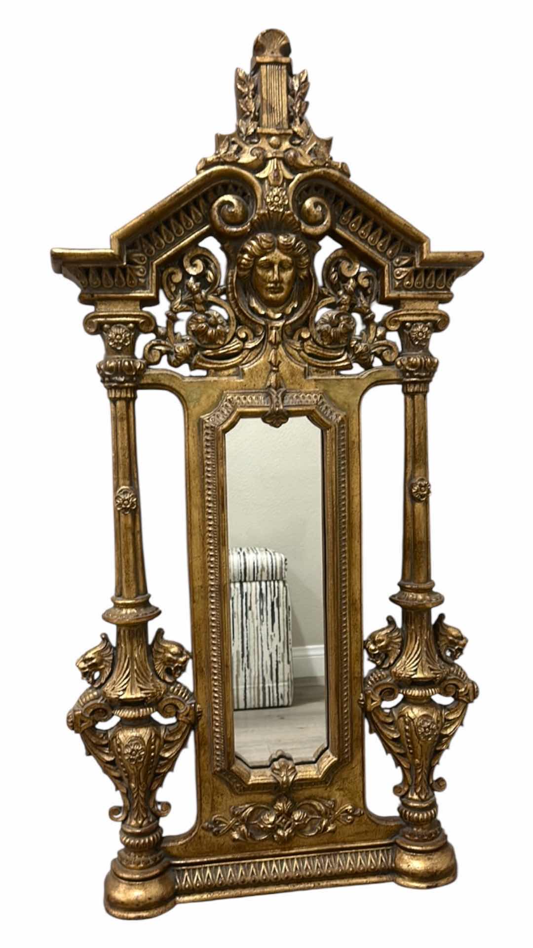 Photo 1 of ITALIAN BAROQUE-STYLE FIGURAL MIRROR FEATURING A GOLD GILT FINISH, A LARGE CENTRAL FEMALE FACE CREST, AND WINGED GRIFFINS ON THE BASE. 25” x H53“