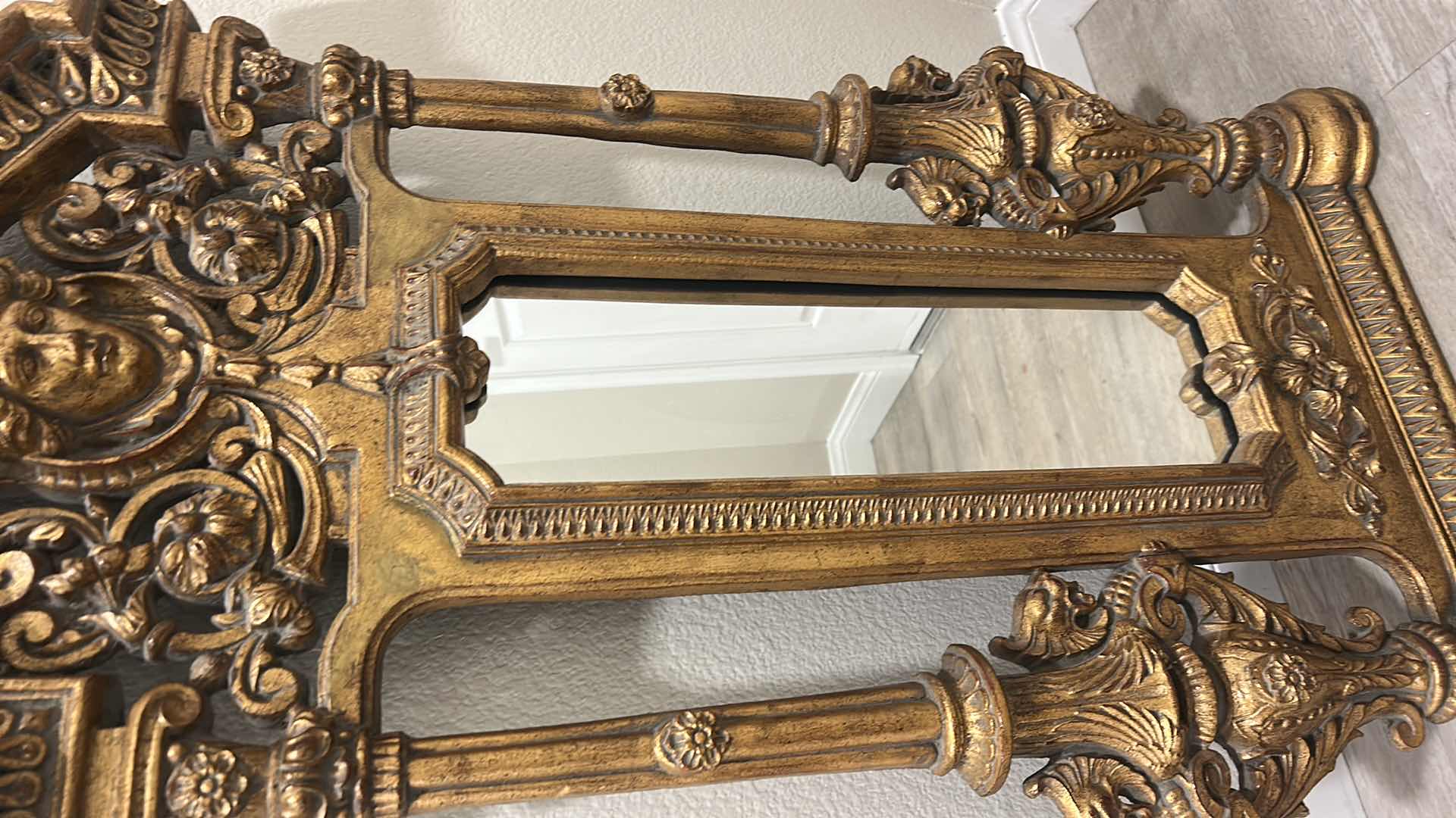 Photo 1 of ITALIAN BAROQUE-STYLE FIGURAL MIRROR FEATURING A GOLD GILT FINISH, A LARGE CENTRAL FEMALE FACE CREST, AND WINGED GRIFFINS ON THE BASE. 25” x H53“