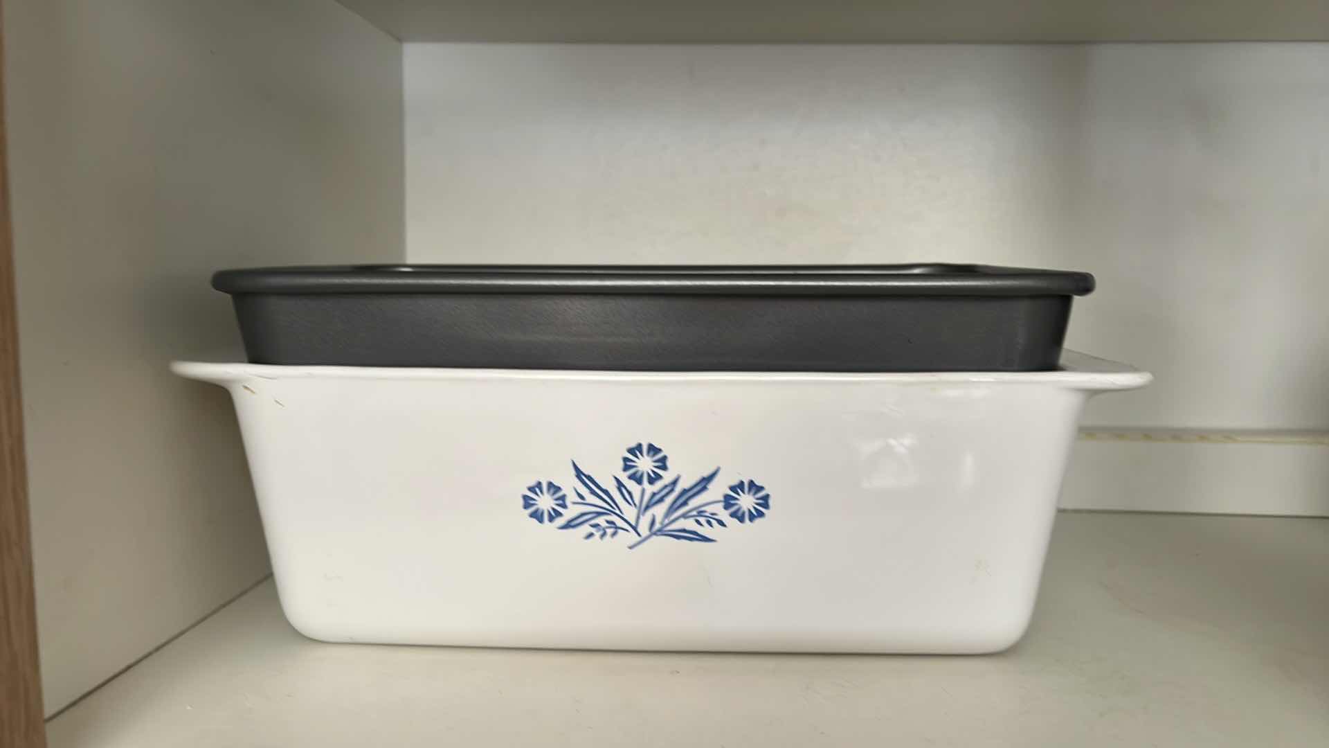 Photo 1 of CONTENTS OF KITCHEN CABINET (LEFT SIDE ONLY). BAKING PANS, PYREX CORNINGWARE, BREAD PAN, ETC.
