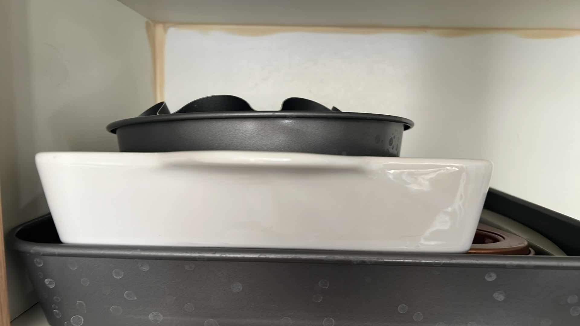 Photo 1 of CONTENTS OF KITCHEN CABINET (LEFT SIDE ONLY). BAKING PANS, PYREX CORNINGWARE, BREAD PAN, ETC.
