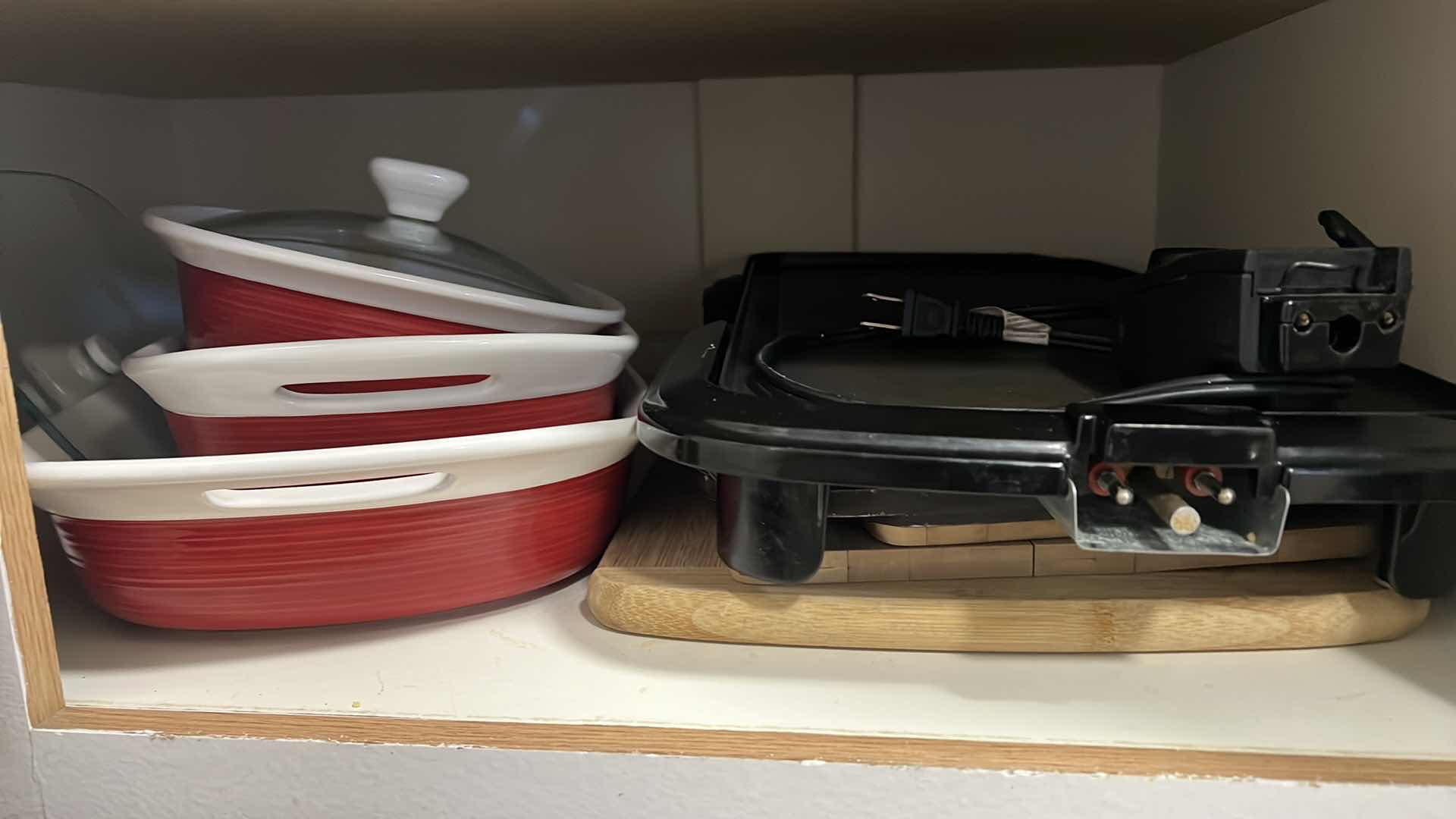 Photo 1 of CONTENTS OF KITCHEN SHELF. BAKING CASSEROLE DISHES. ELECTRIC PLUG IN GRIDDLE, AND CUTTING BOARDS.
