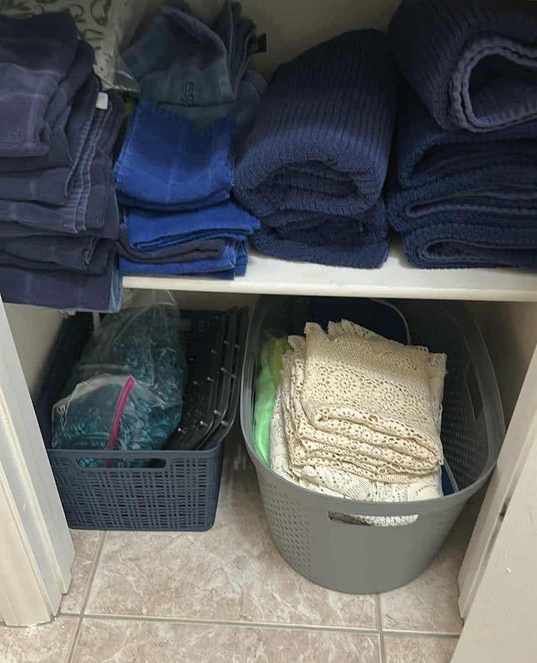 Photo 1 of CONTENTS OF SHELF DARK BLUE BATH TOWELS AND 2 BASKETS W LACE RUNNERS 