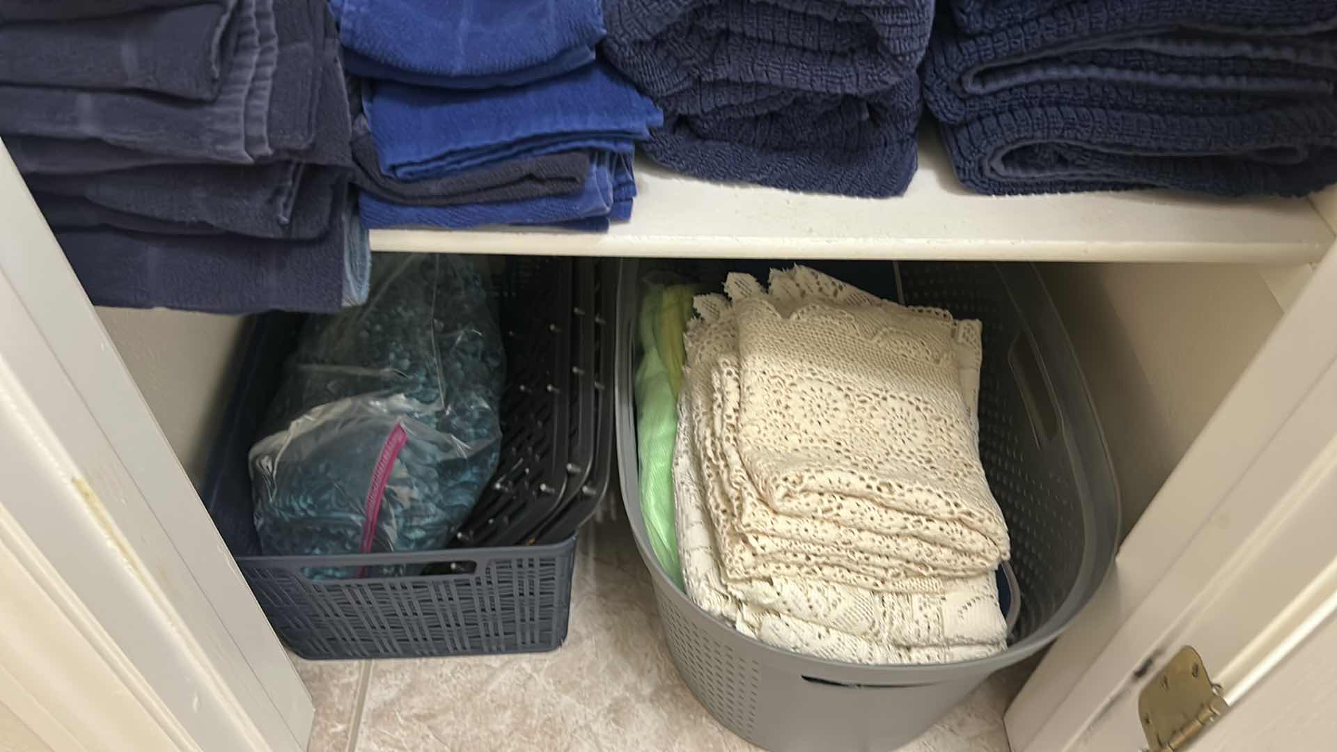 Photo 1 of CONTENTS OF SHELF DARK BLUE BATH TOWELS AND 2 BASKETS W LACE RUNNERS 