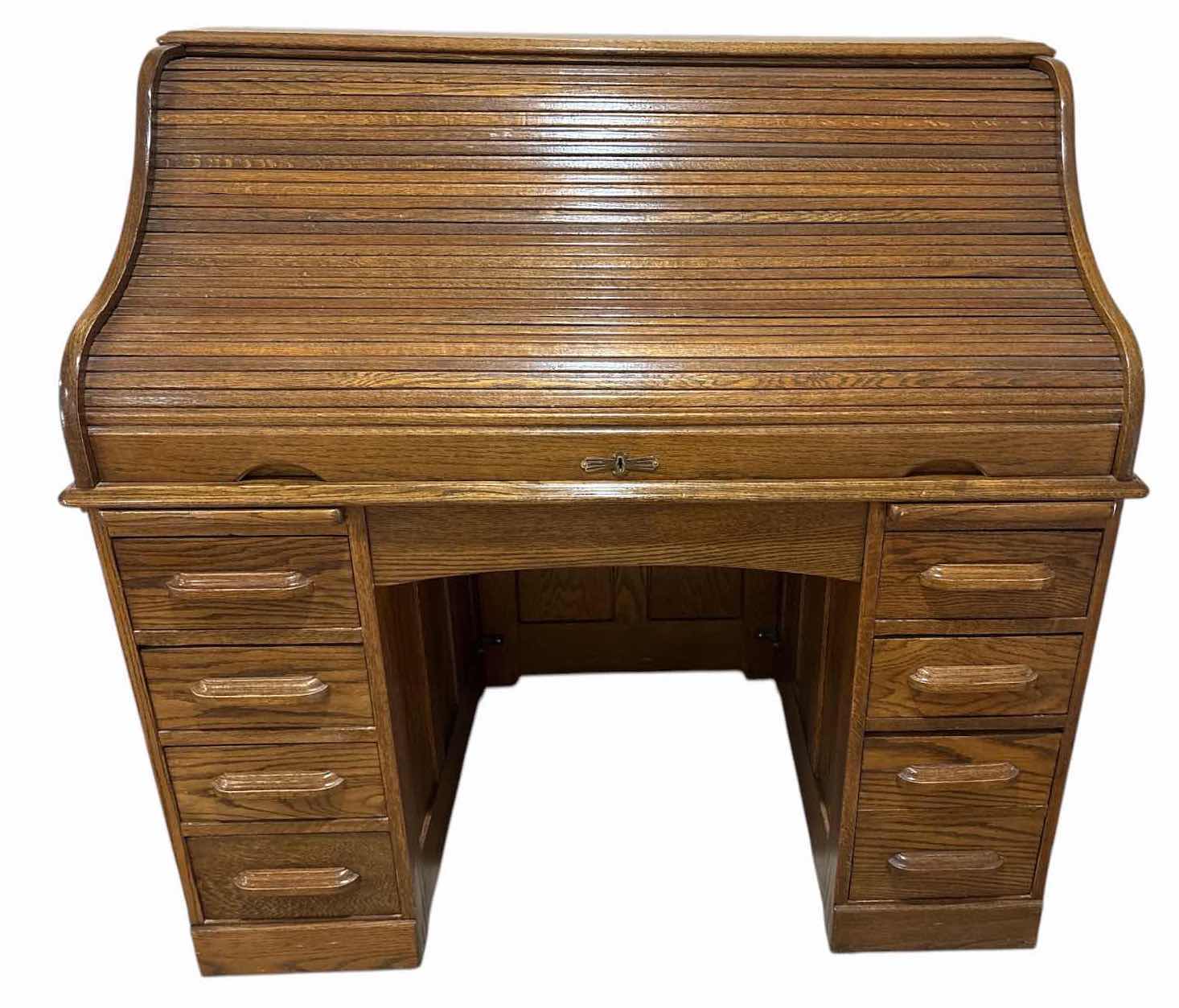 View 1 of SOLID OAK ROLL TOP DESK W 8 STORAGE DRAWERS, CENTER KNEEHOLE, AND LOCKABLE ROLL-TOP COVER (KEY NOT INCLUDED) 49”X29”H47.5” $900