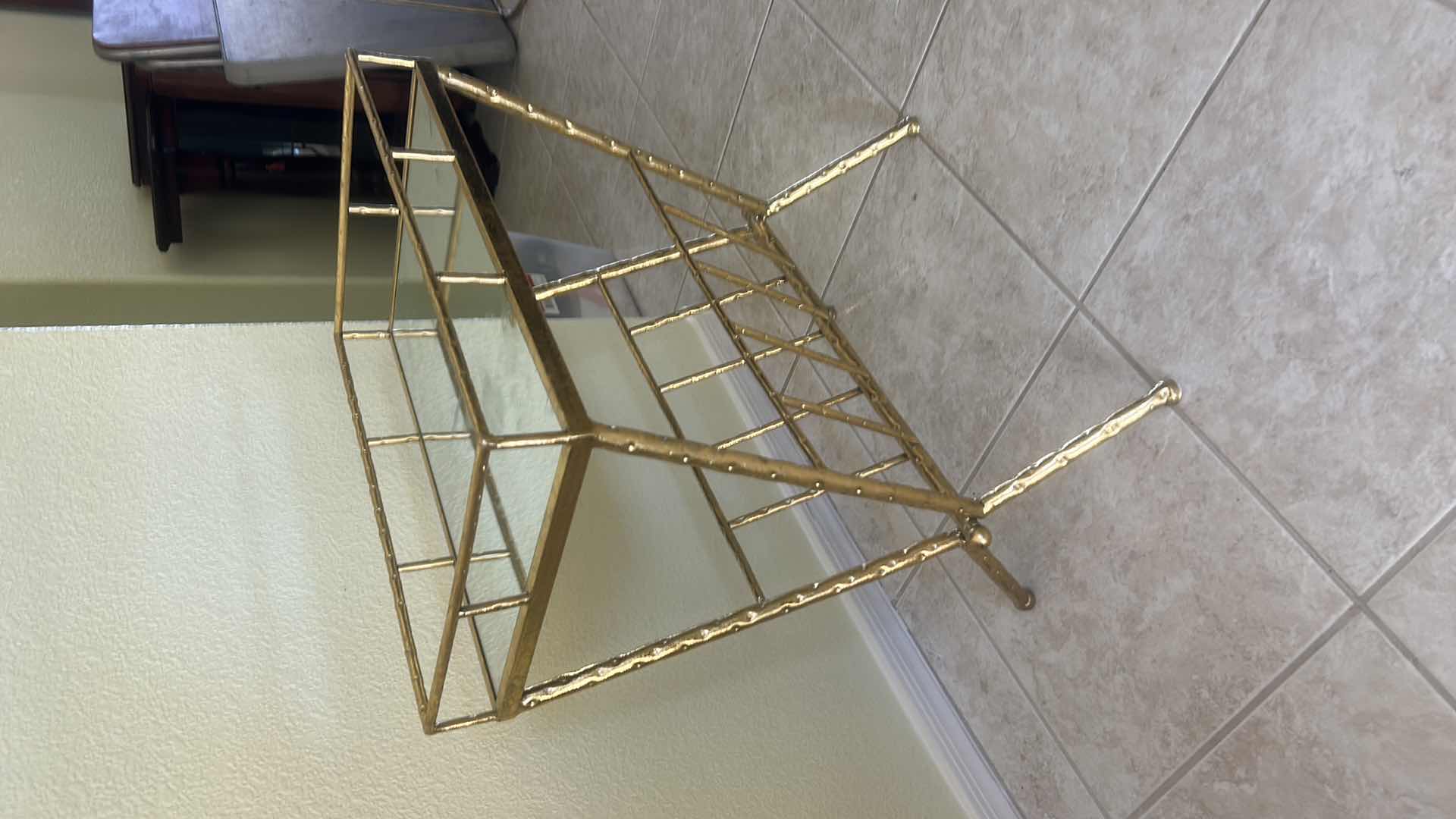 Photo 1 of VINTAGE-STYLE GOLD METAL MAGAZINE RACK FEATURING GLASS PANELS, A DECORATIVE HAMMERED FINISH, AND AN OPEN STORAGE COMPARTMENT 18 1/4“ x 12“ x H23“ $60